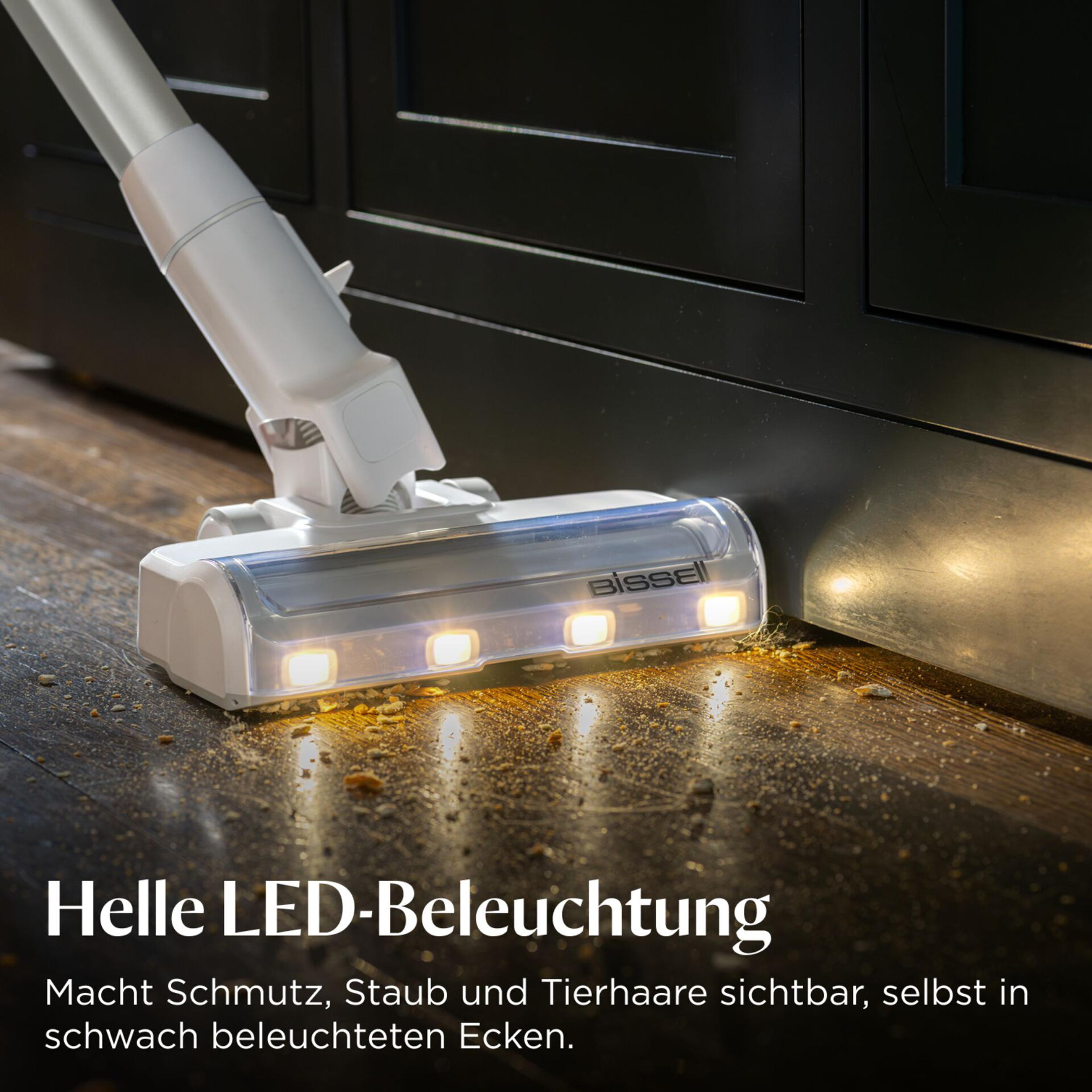 Ein Staubsaugeraufsatz mit LEDs reinigt Holzboden von Krümeln.