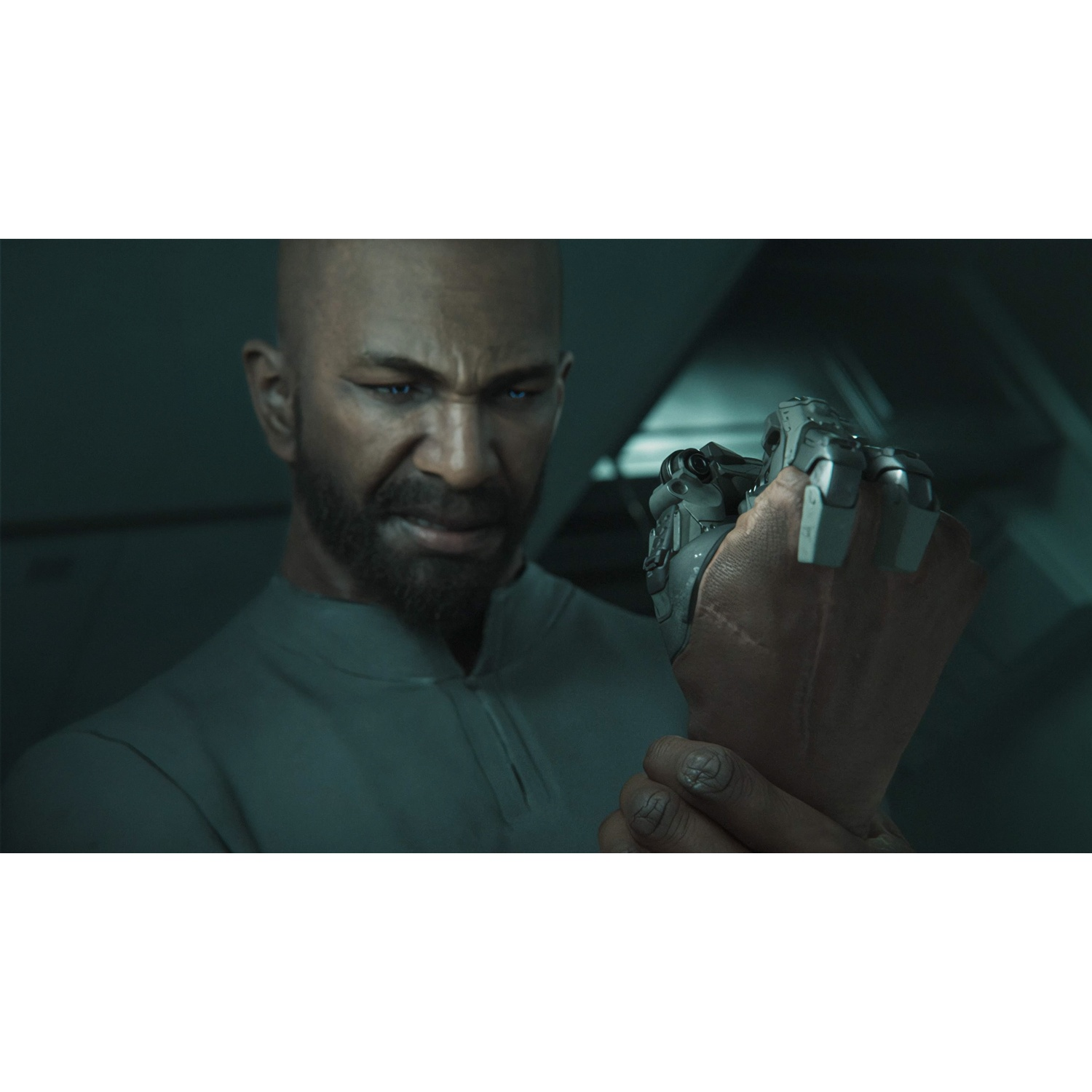 Un homme chauve avec une barbe examine une main mécanique attachée à son bras.