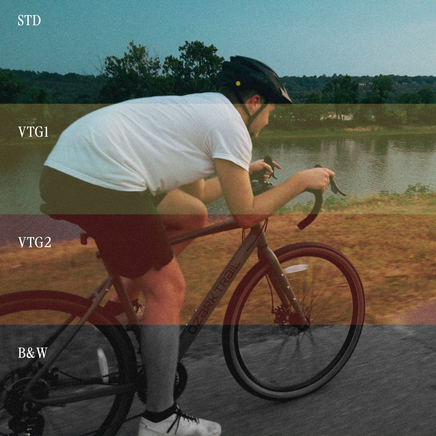 A man rides a bicycle wearing a helmet by the water.