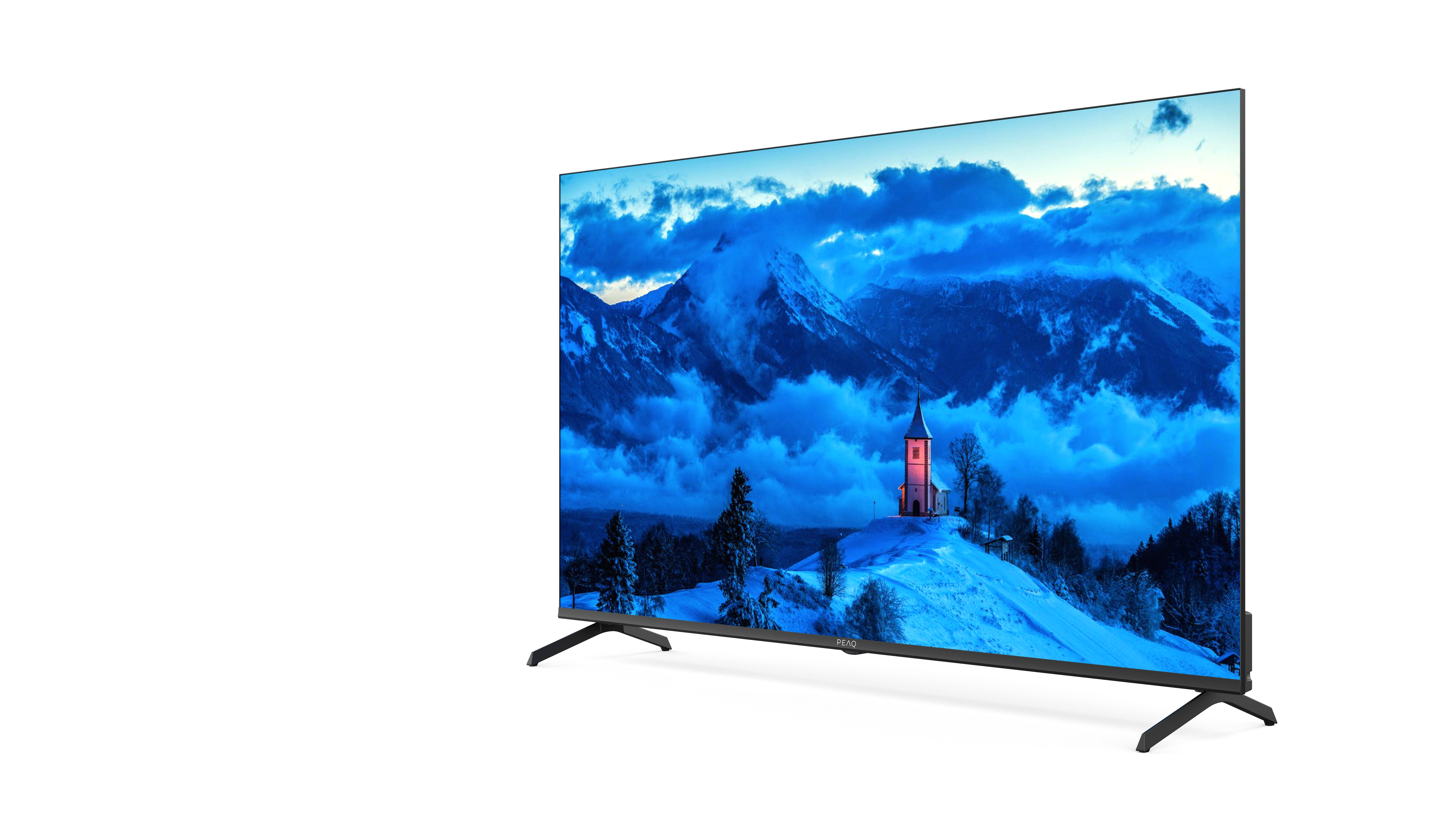 Nowoczesny telewizor wyświetla ośnieżoną górską wioskę z kościołem nocą.