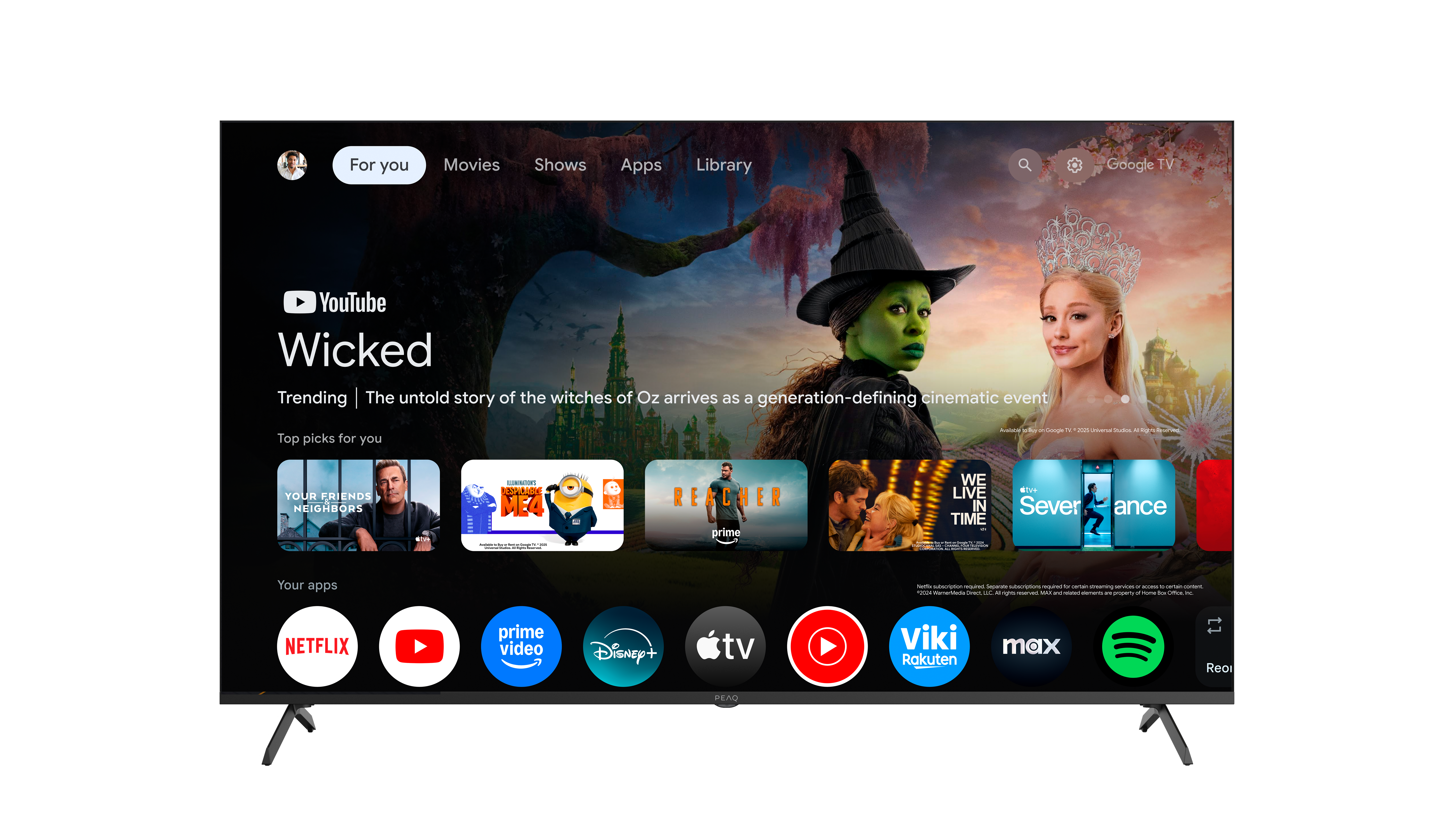 Ekran główny Google TV z plakatami filmów i ikonami aplikacji. Po lewej stronie jest Zła Czarownica.