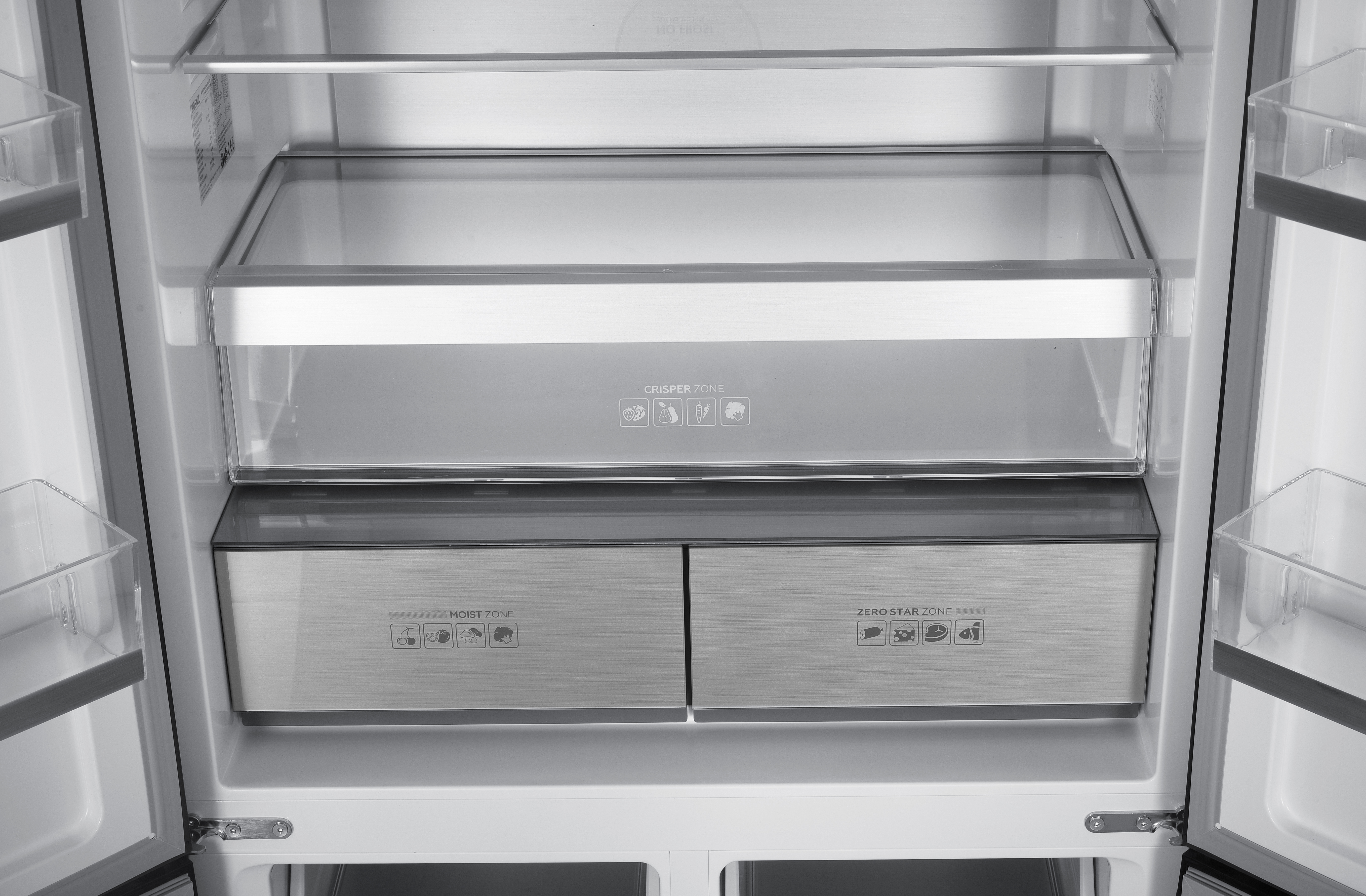 Un refrigerador abierto muestra estantes, cajones con etiquetas como 'Crisper Zone'.