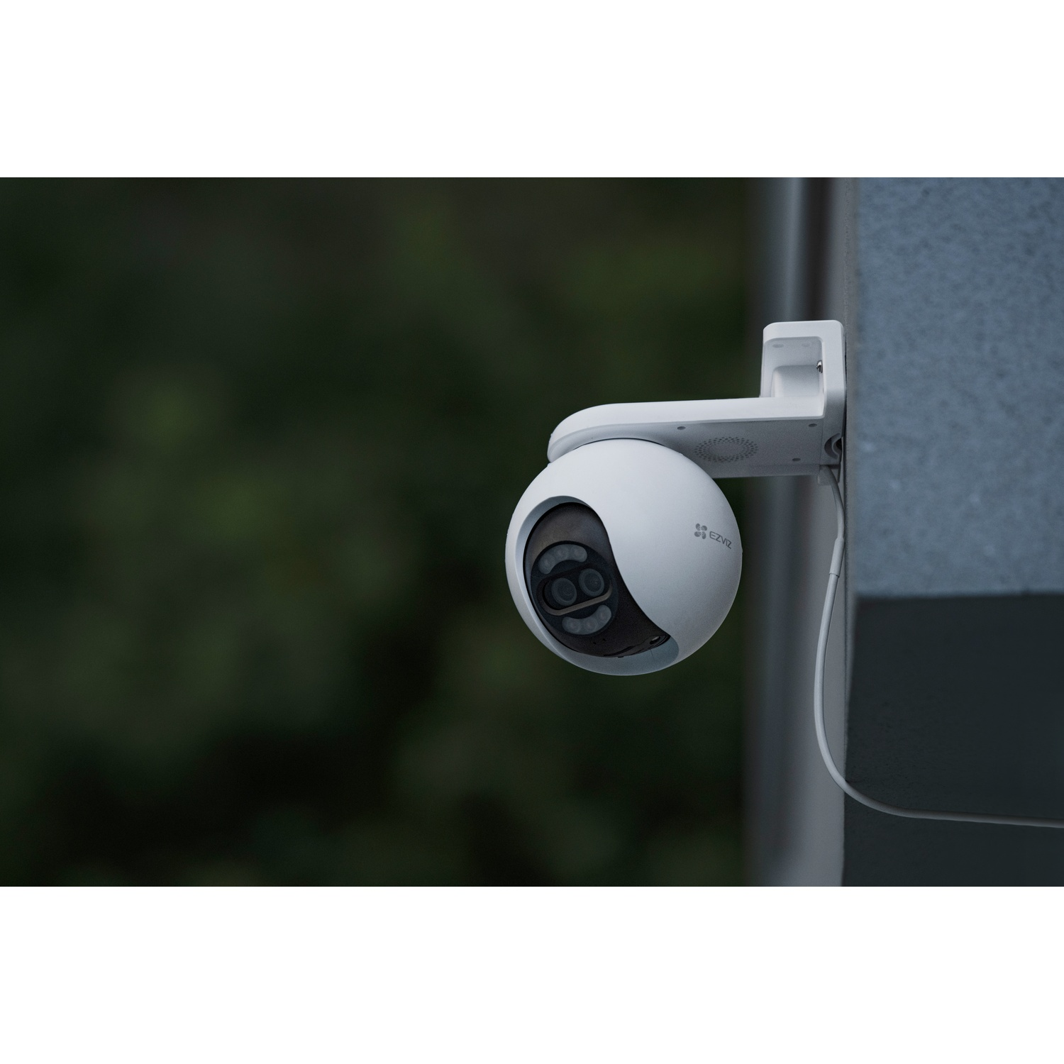 A white security camera with EZVIZ logo is mounted on a wall.