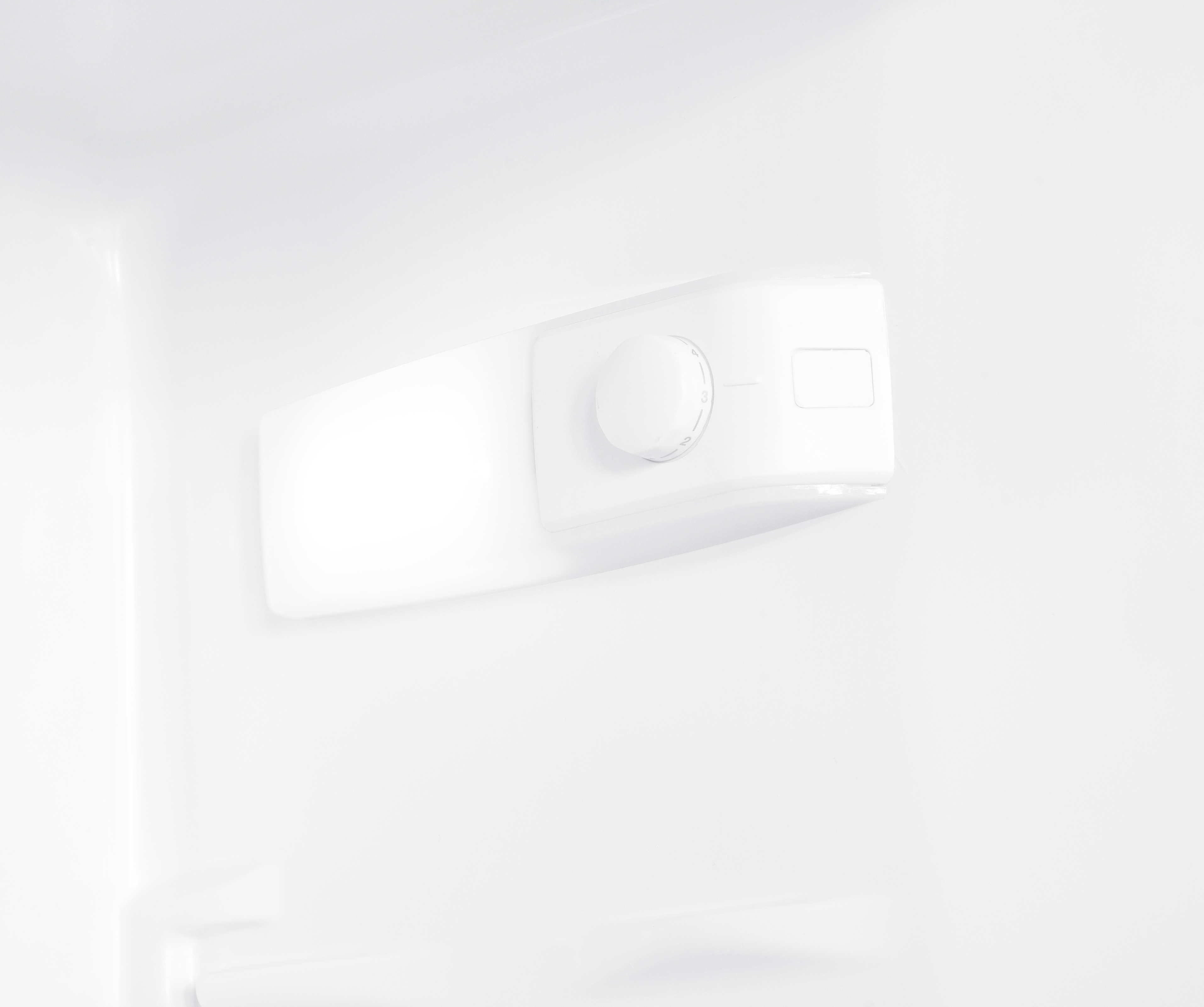 Un dial giratorio blanco con marcas y un pequeño campo rectangular.