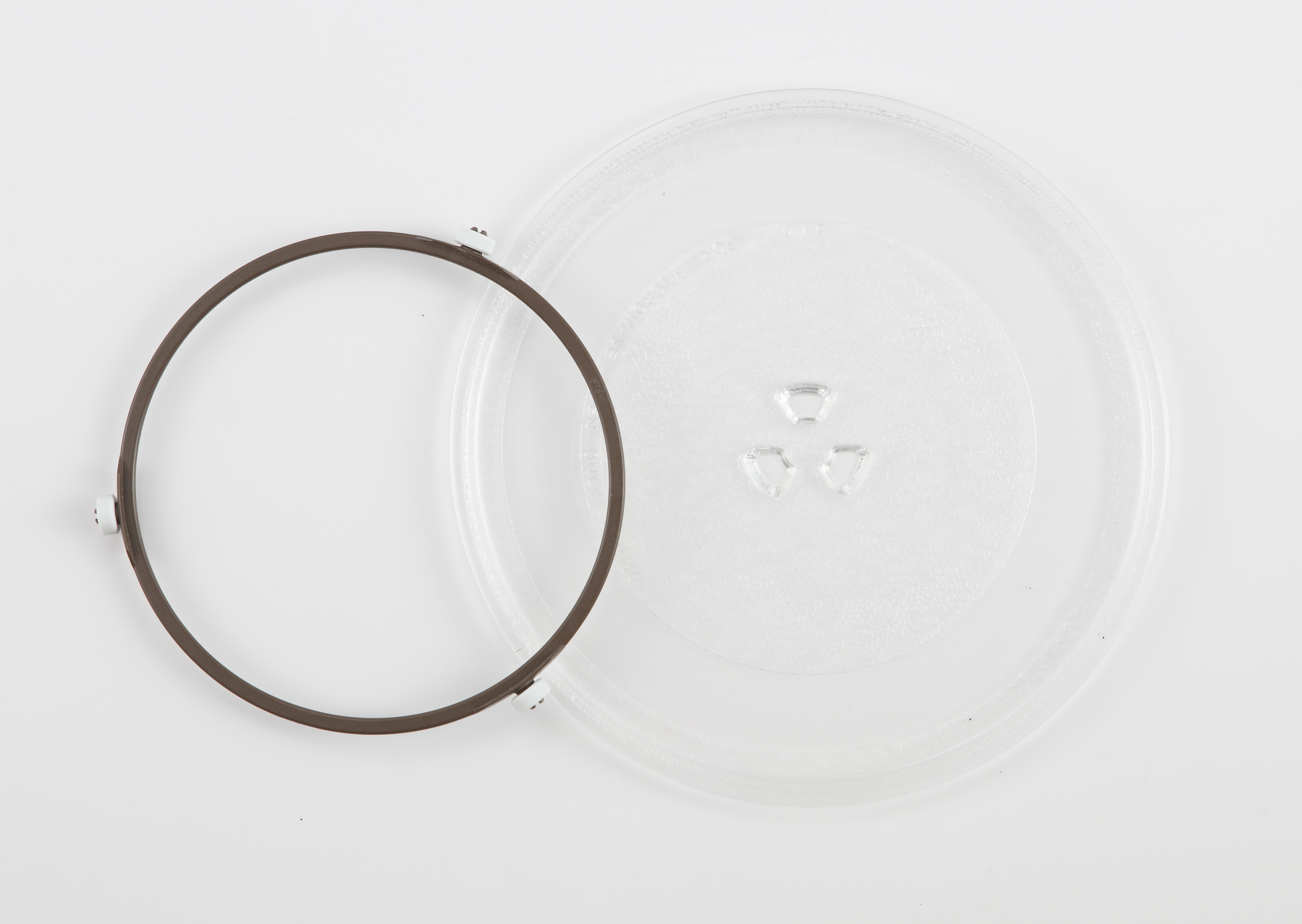 Un plato giratorio redondo de vidrio con tres hendiduras y un anillo marrón con soportes blancos.
