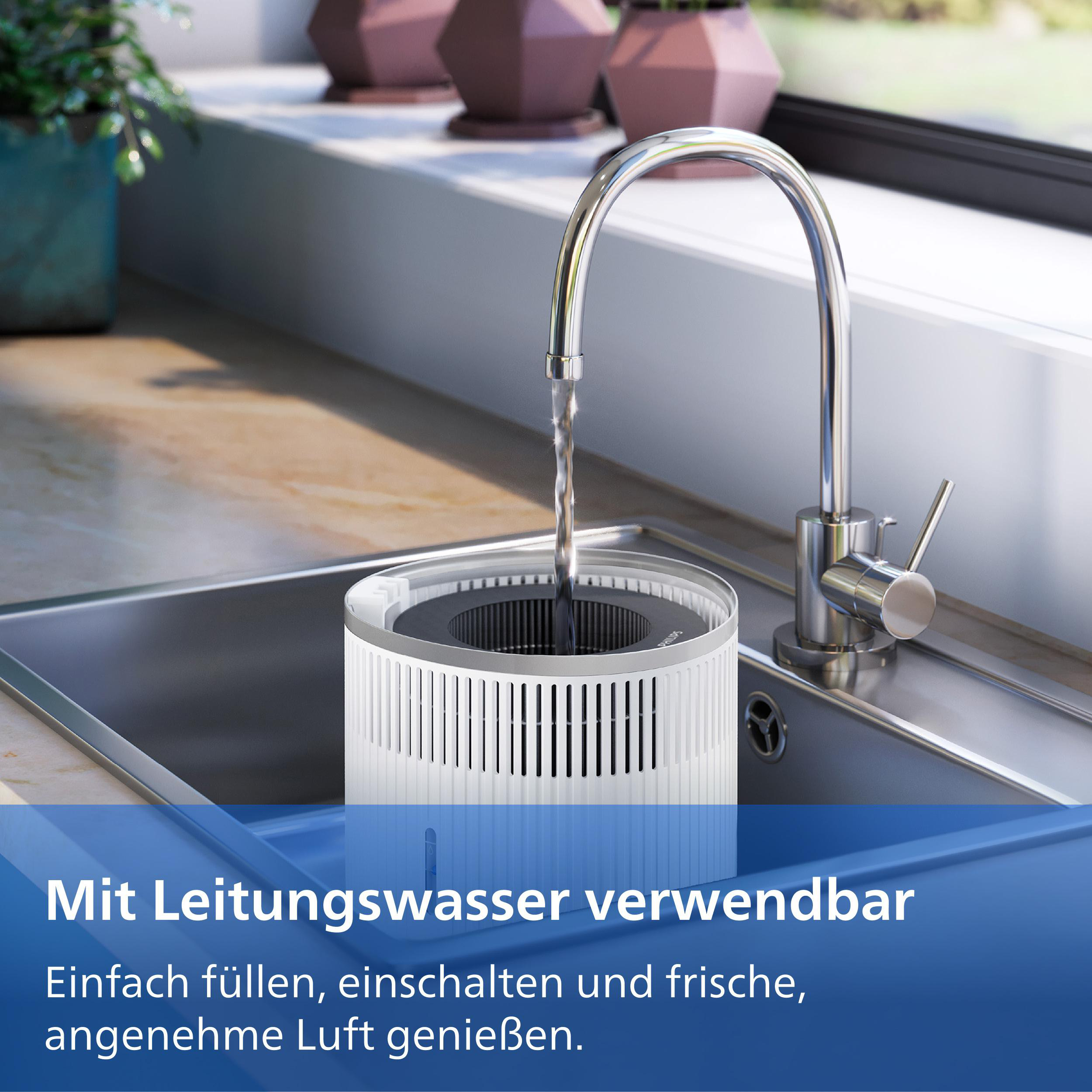 Ein weißer Luftreiniger wird in einer Spüle mit Wasser gefüllt.