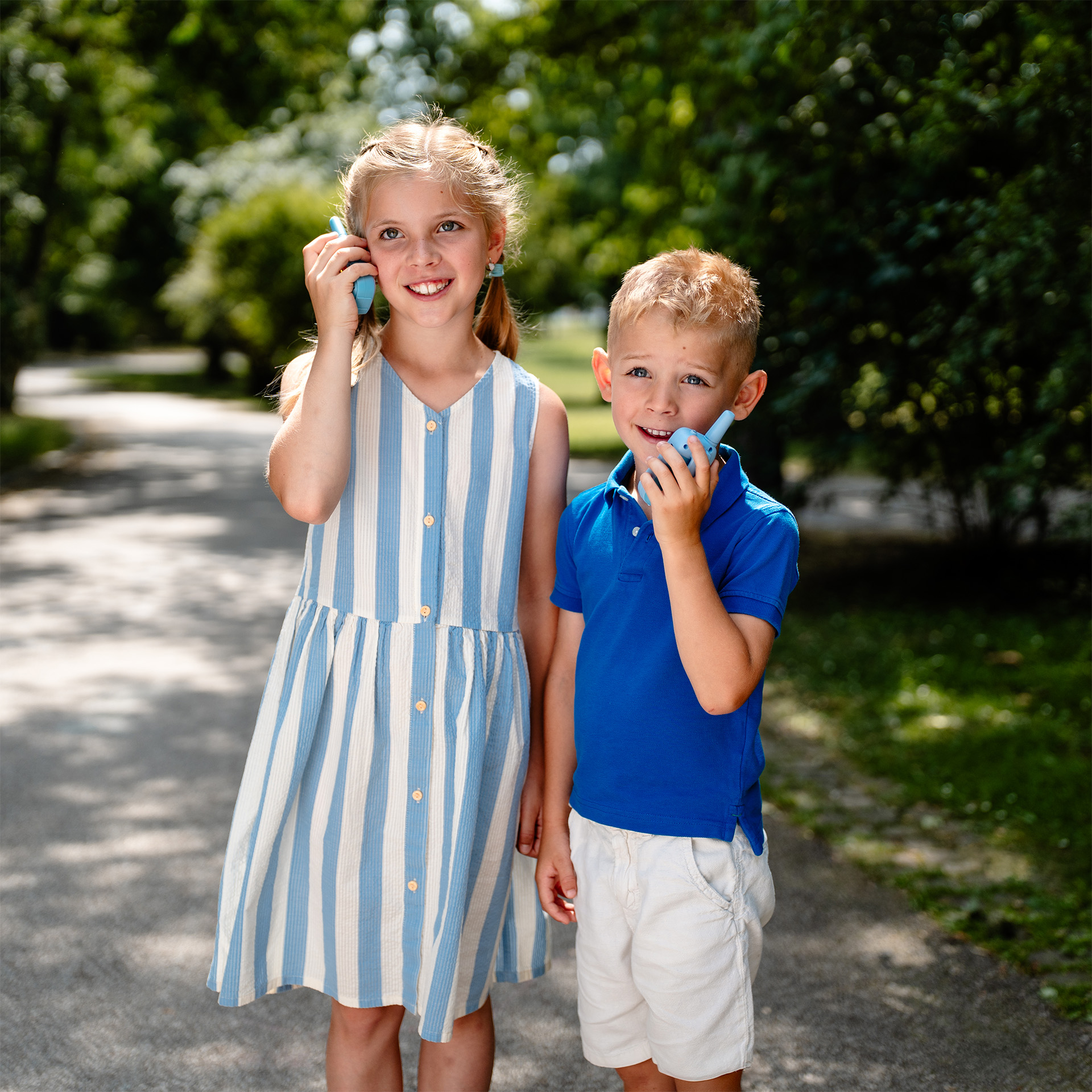 Lány és fiú walkie-talkie-val a szabadban.