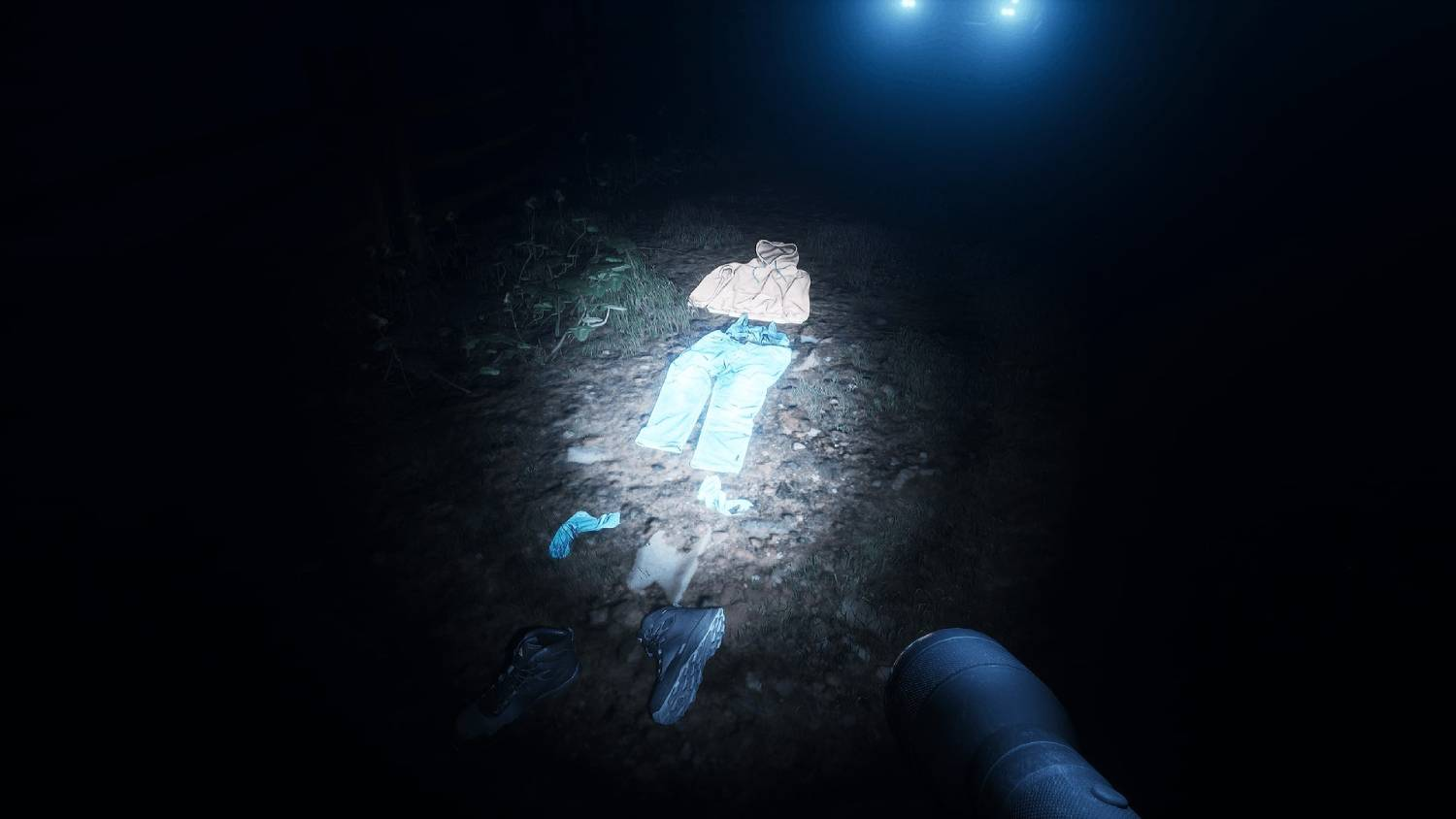 Ropa en el suelo, iluminada por linternas. Zapatos y calcetines cerca.