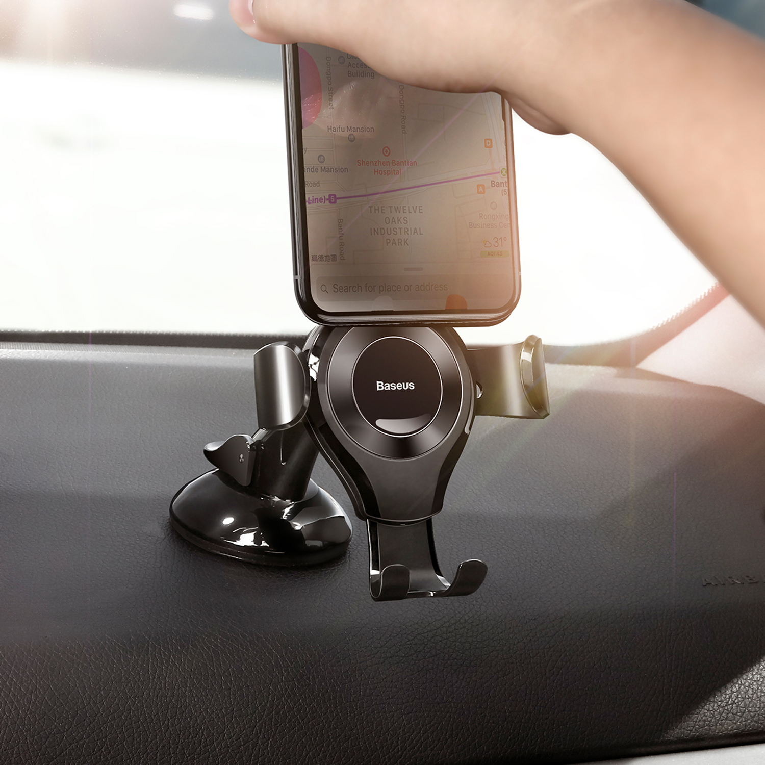 Teléfono en soporte de coche muestra app de mapas en salpicadero. Mano coloca teléfono.