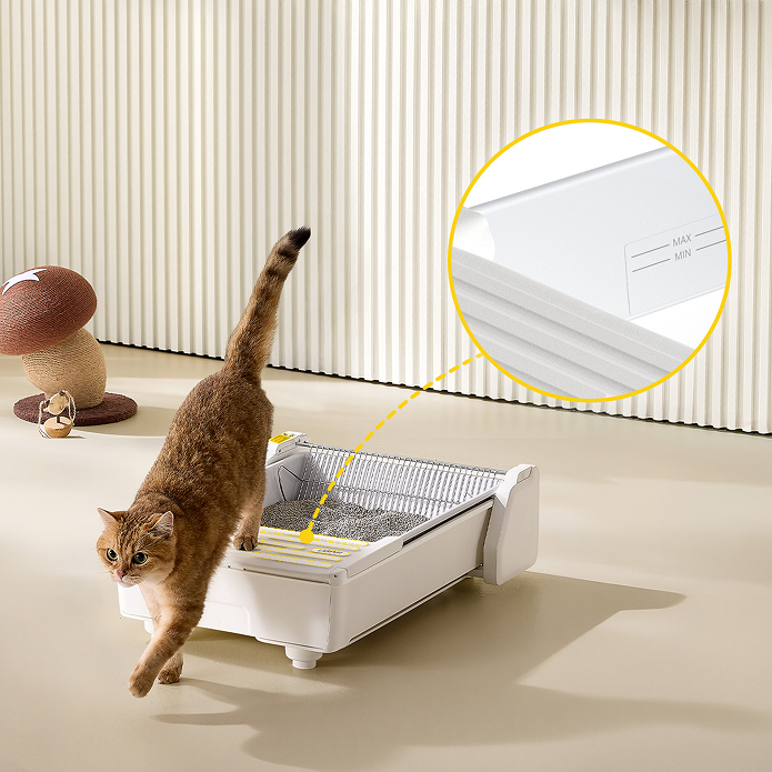 Eine Katze steigt aus einer weißen Katzentoilette. Nahaufnahme zeigt MAX/MIN-Markierungen.