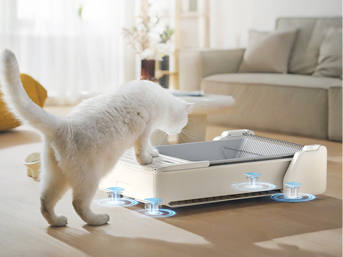 Eine weiße Katze steht vor einer modernen Katzentoilette mit blauen Lichtern.