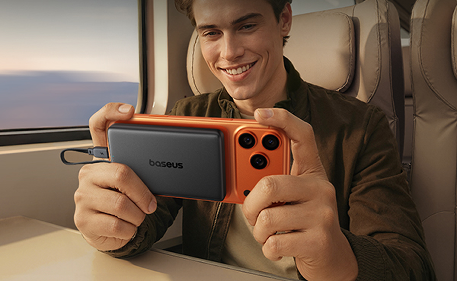Hombre carga móvil en tren con power bank.