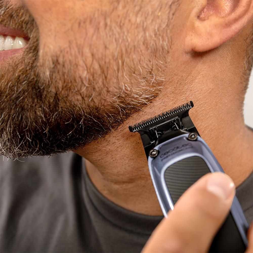 Hombre recortándose la barba con una recortadora. Primer plano.
