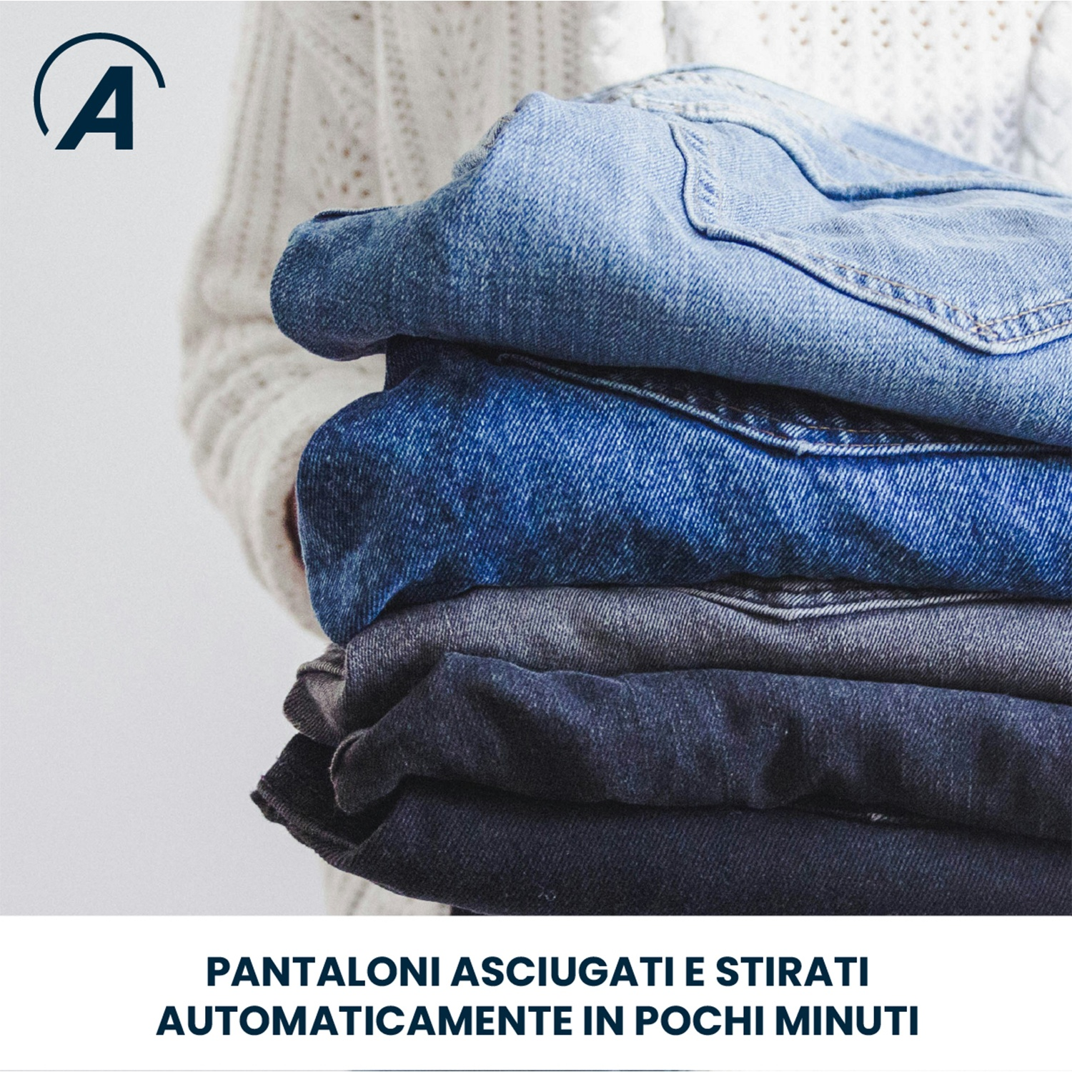 Una pila di jeans in varie tonalità di blu tenuta da una persona con un maglione bianco.
