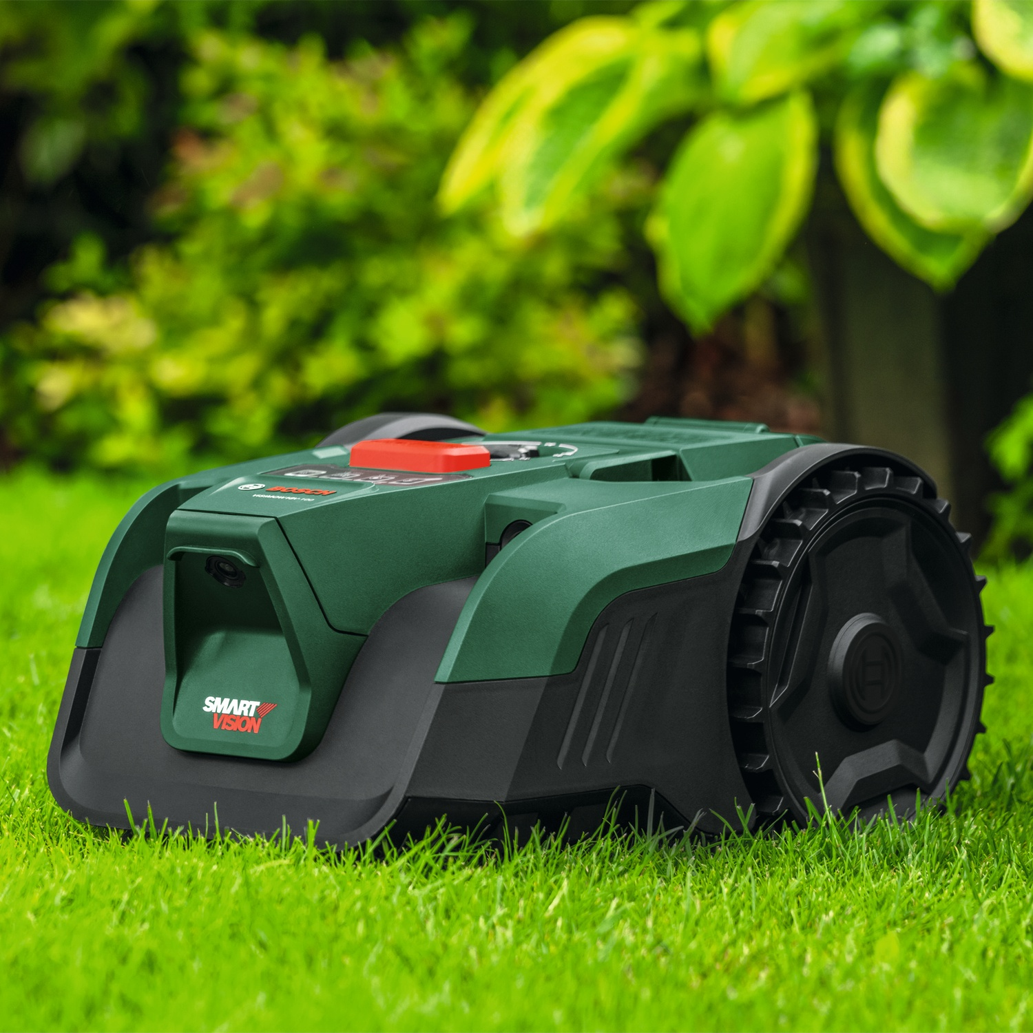 Un robot tagliaerba verde con ruote nere è su un prato verde.