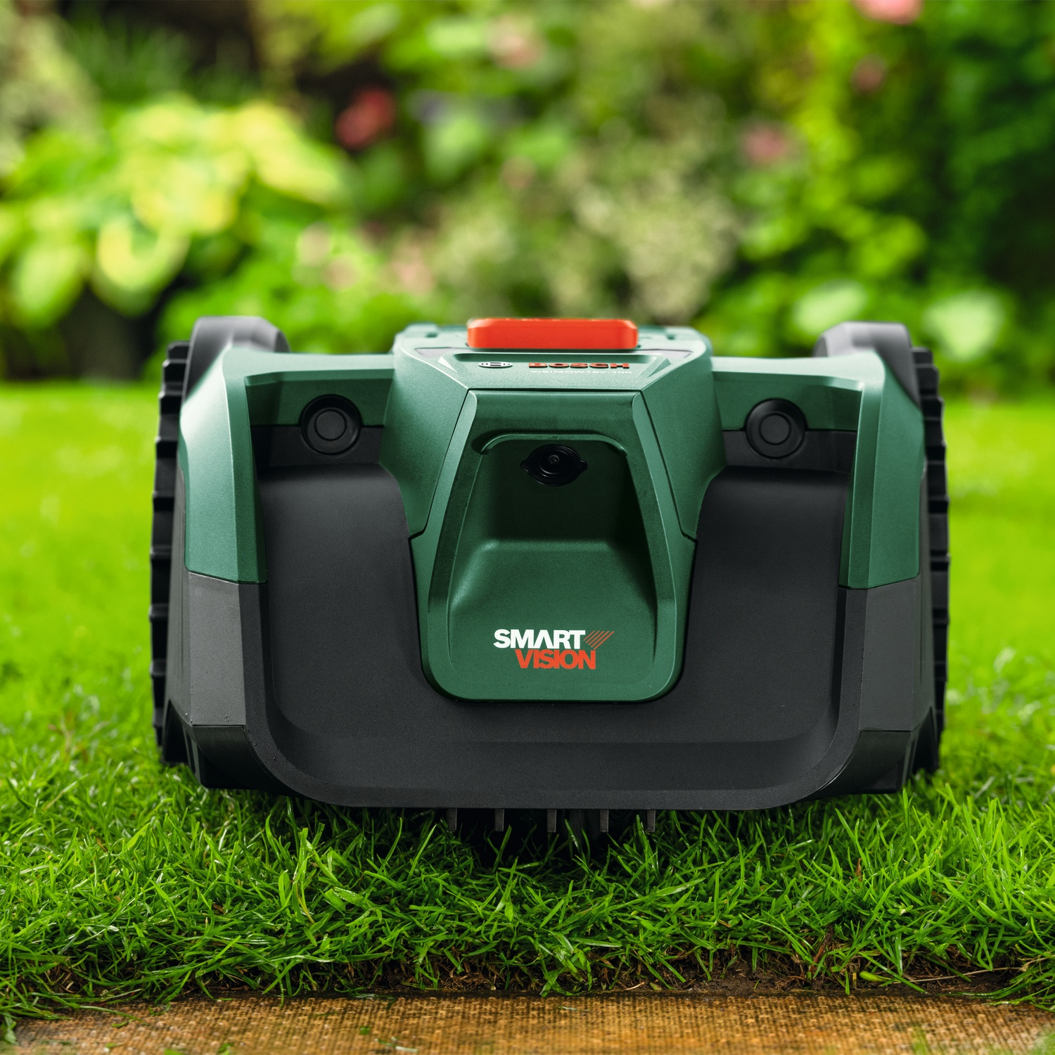 Tosaerba robot verde con pulsante rosso su prato.