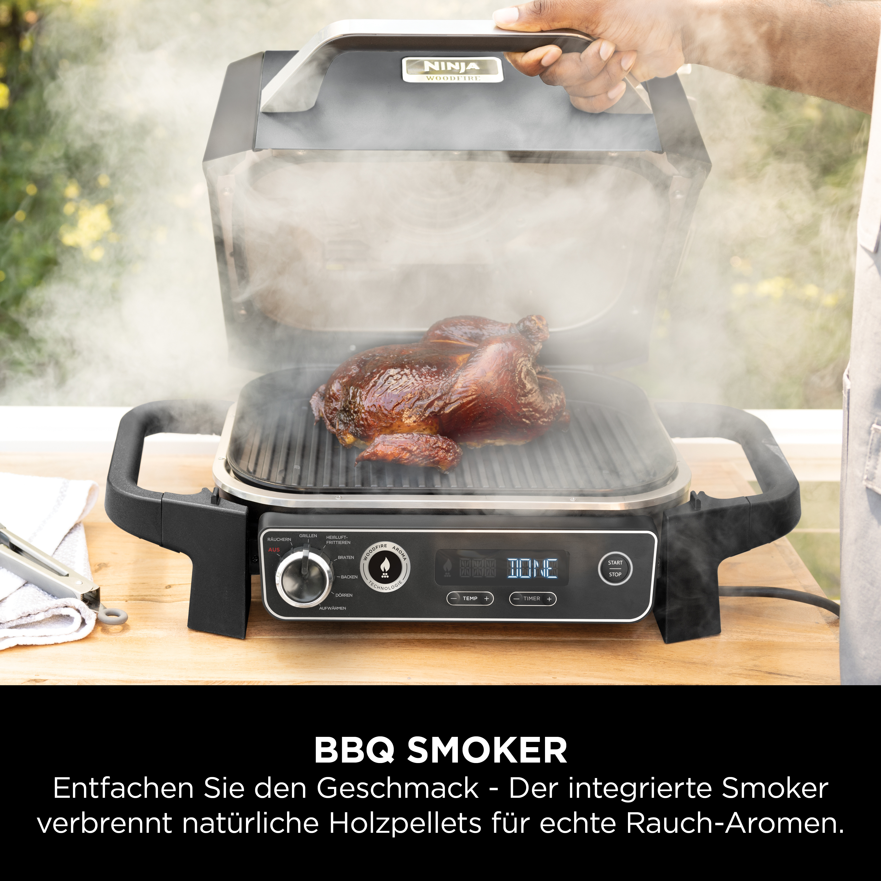 Ein gebratenes Hähnchen wird in einem Ninja Woodfire Grill mit Dampf geräuchert.