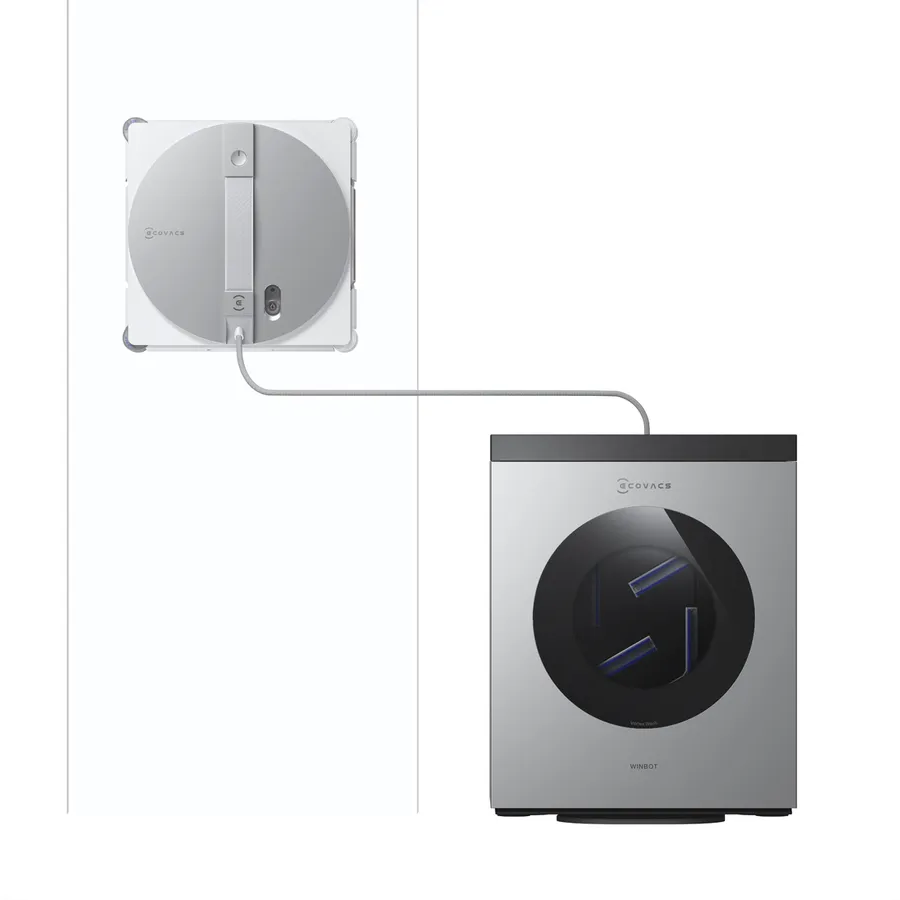 Ein Roboter-Fensterreiniger haftet an einer Wand, verbunden mit einer Ladestation.