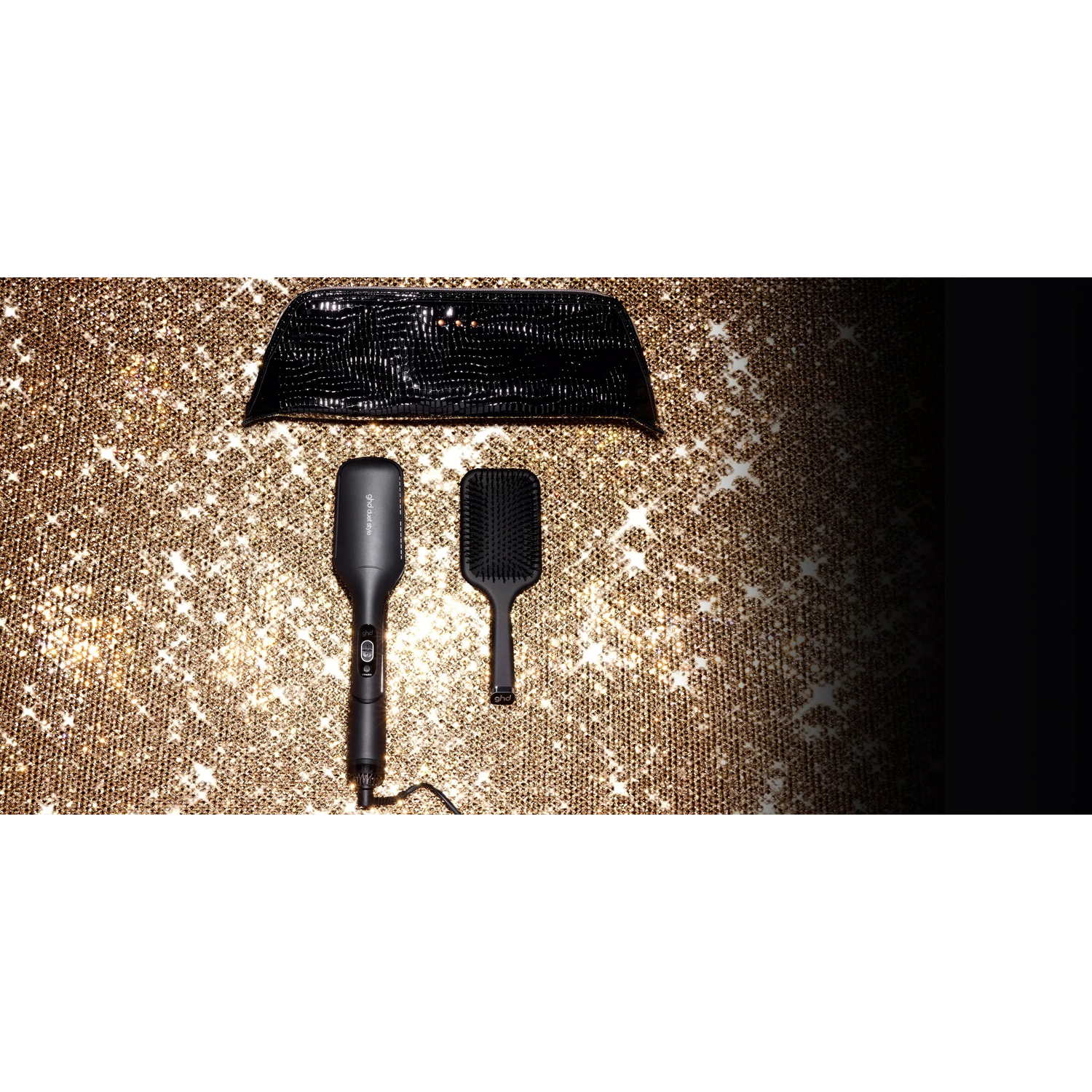 Black hair styling set with straightener and brush on a sparkly gold background.