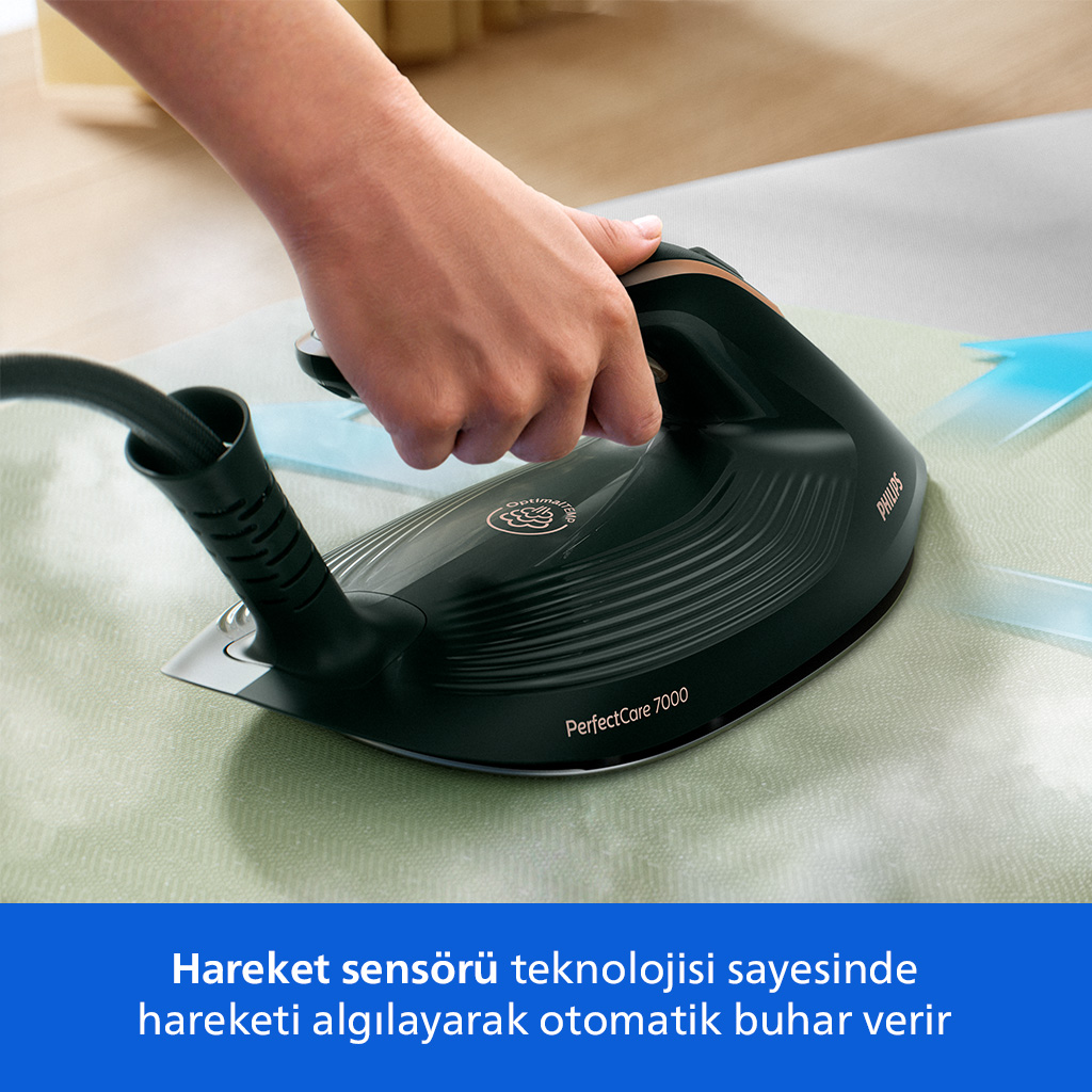 El açık yeşil kumaş ütülüyor. Philips logolu siyah buharlı ütü.