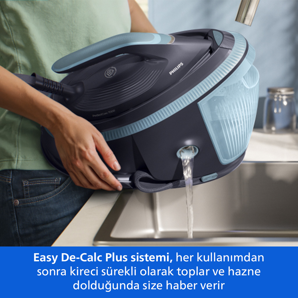 Bir kişi buharlı ütüden lavaboya su boşaltıyor.