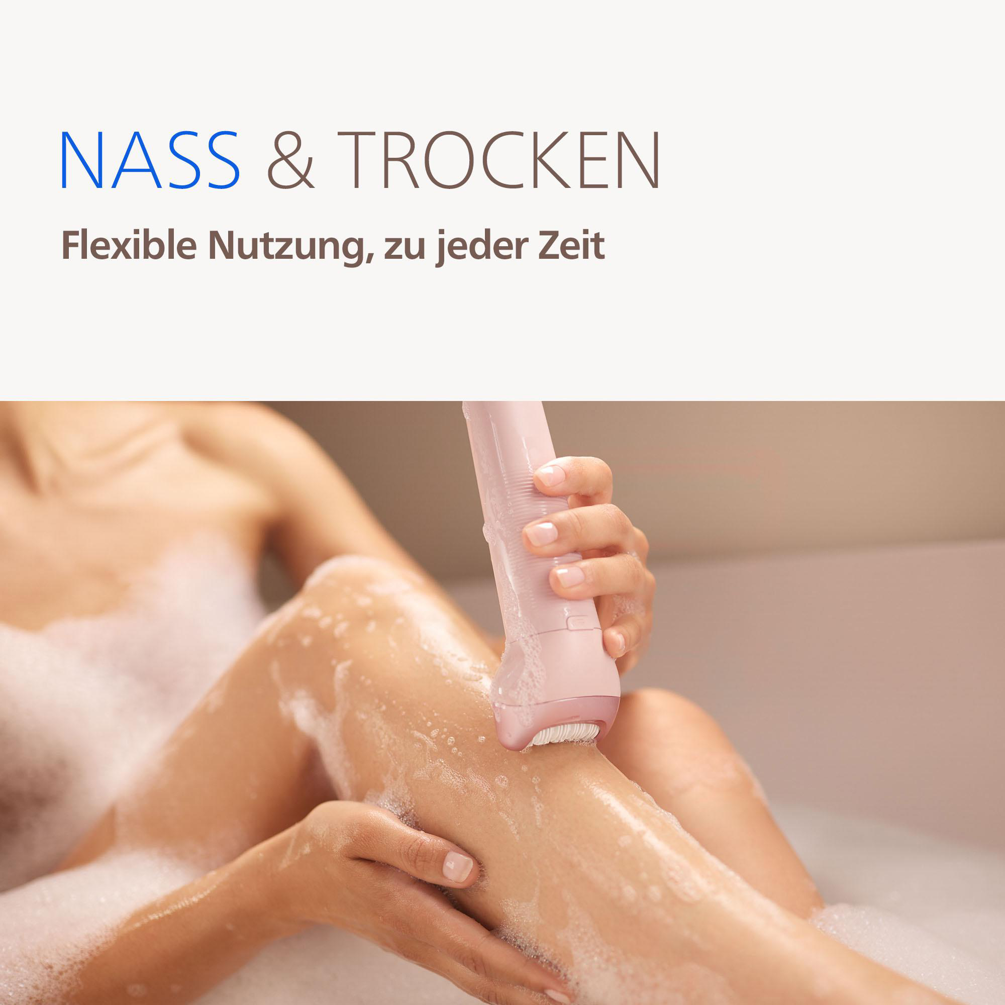 Eine Person rasiert ihr Bein in einer schaumigen Badewanne mit einem rosa Epilierer.