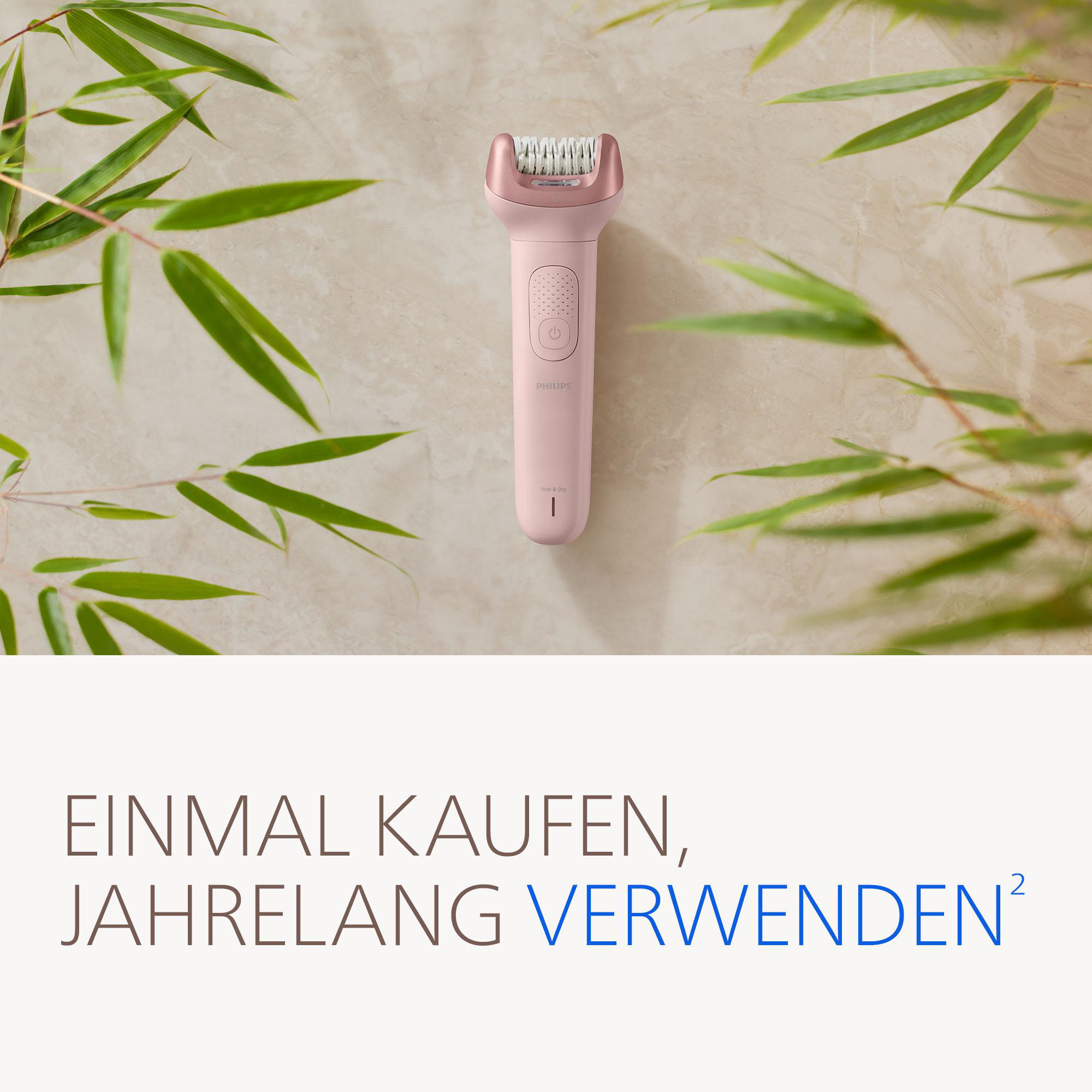 Ein pinker Philips Epilierer mit Bambusblättern auf einem Marmorboden.