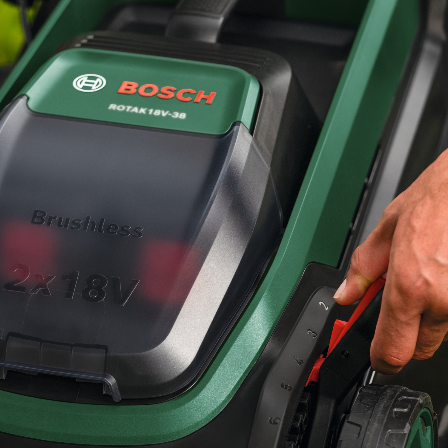 Mano regola leva rossa su tosaerba Bosch verde con indicatore.