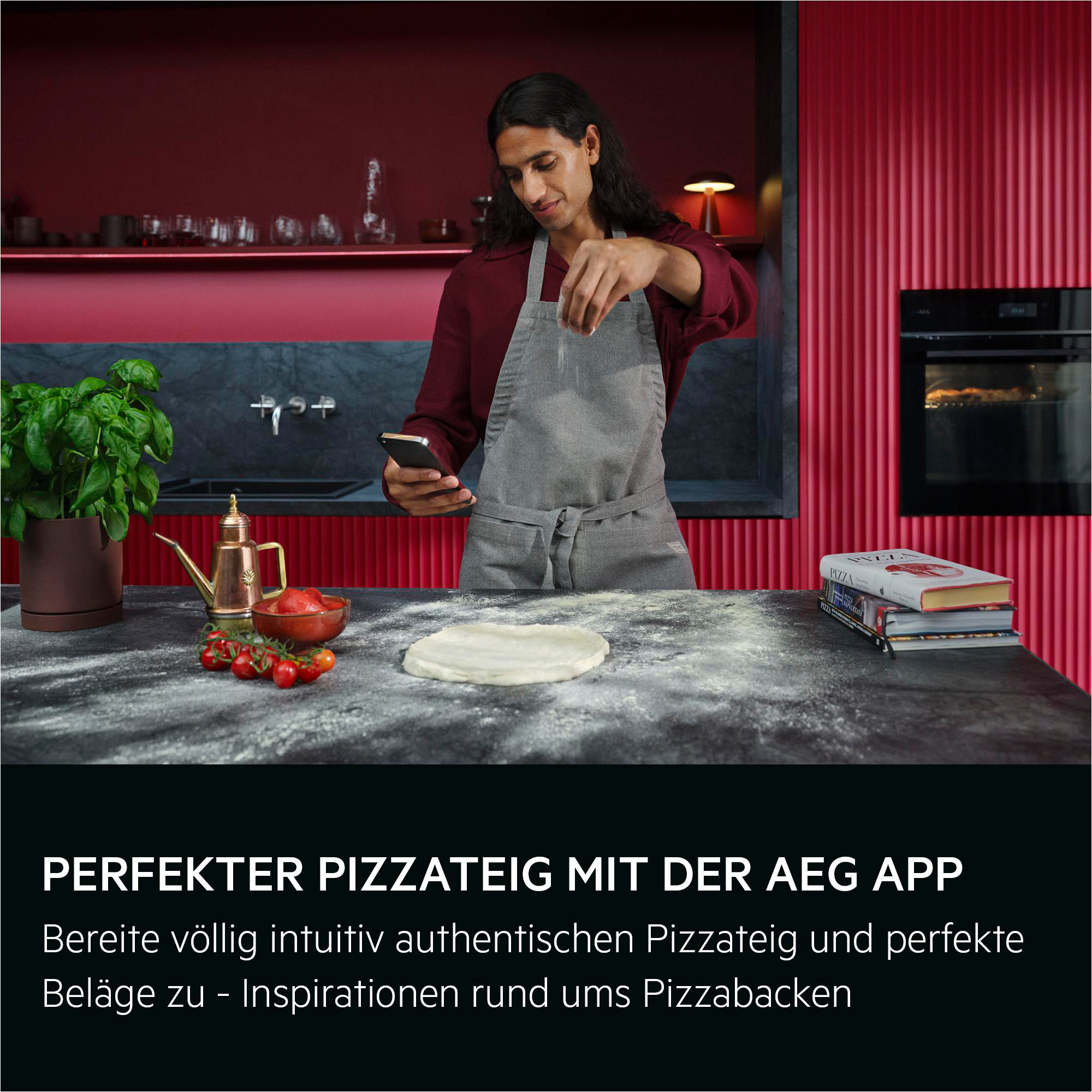 Mann mit Schürze streut Mehl auf Teig, Handy in der Hand.