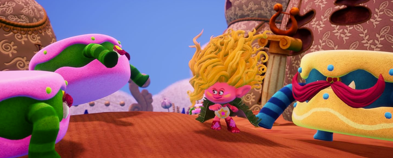 Ein rosa Troll mit blonden Haaren und einem grünen Umhang steht vor bunten Figuren.