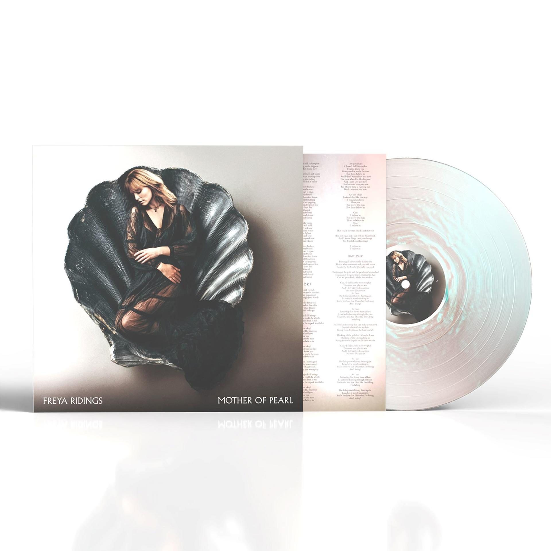 Ein Mann liegt in einer Muschel, daneben das Vinylalbum und Songtexte.