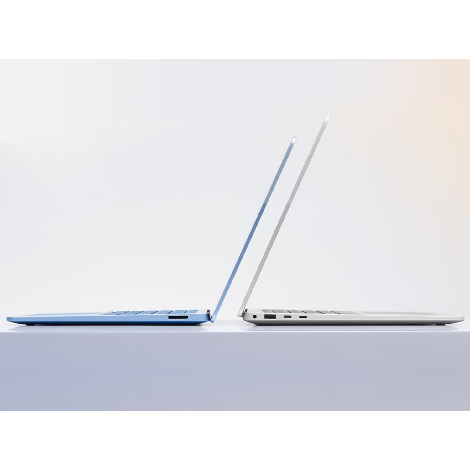 Two laptops, one blue and one silver, stand side by side.