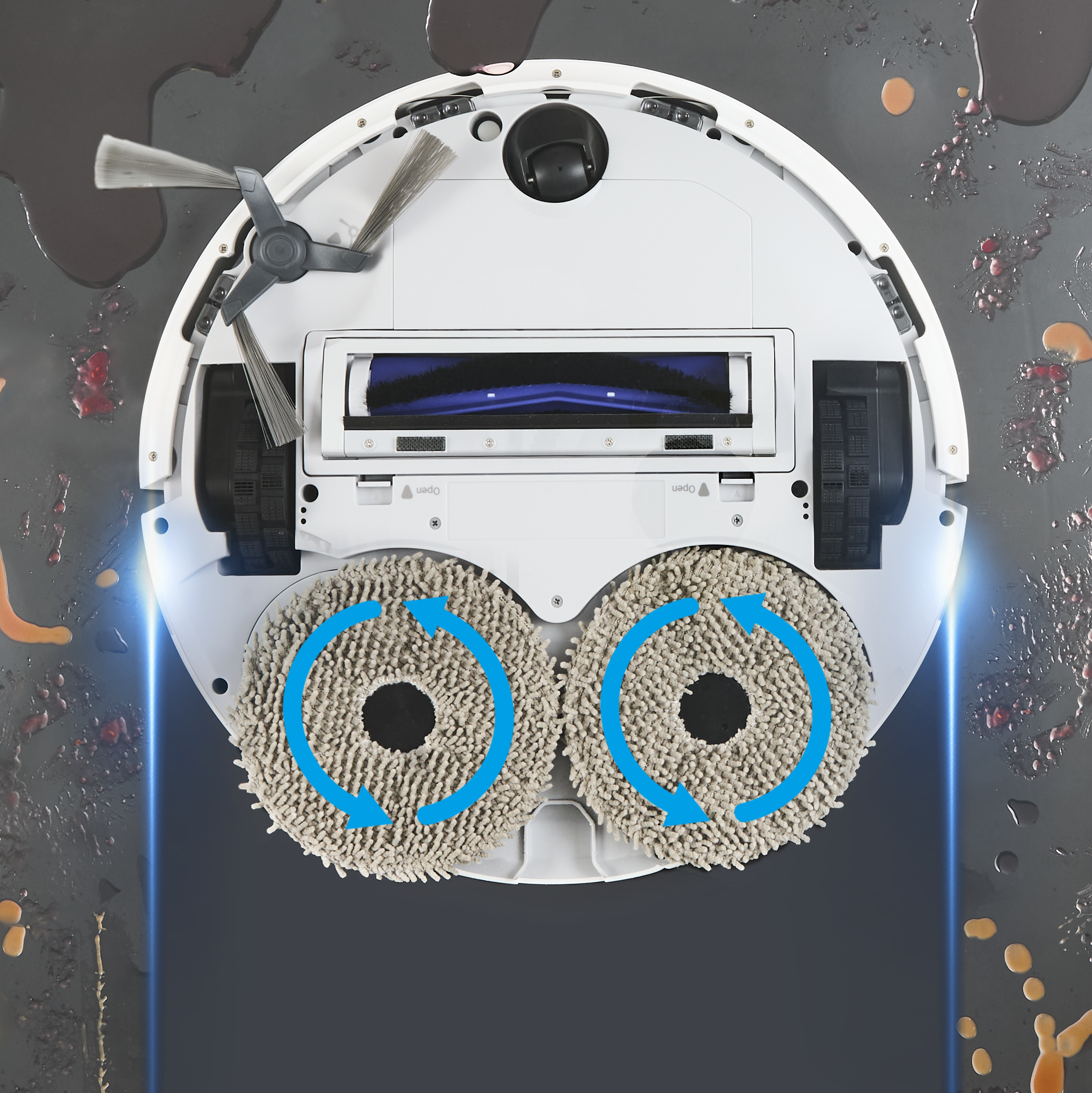 Egy fehér robotporszívó forgó felmosóbetétekkel piszkos padlón.