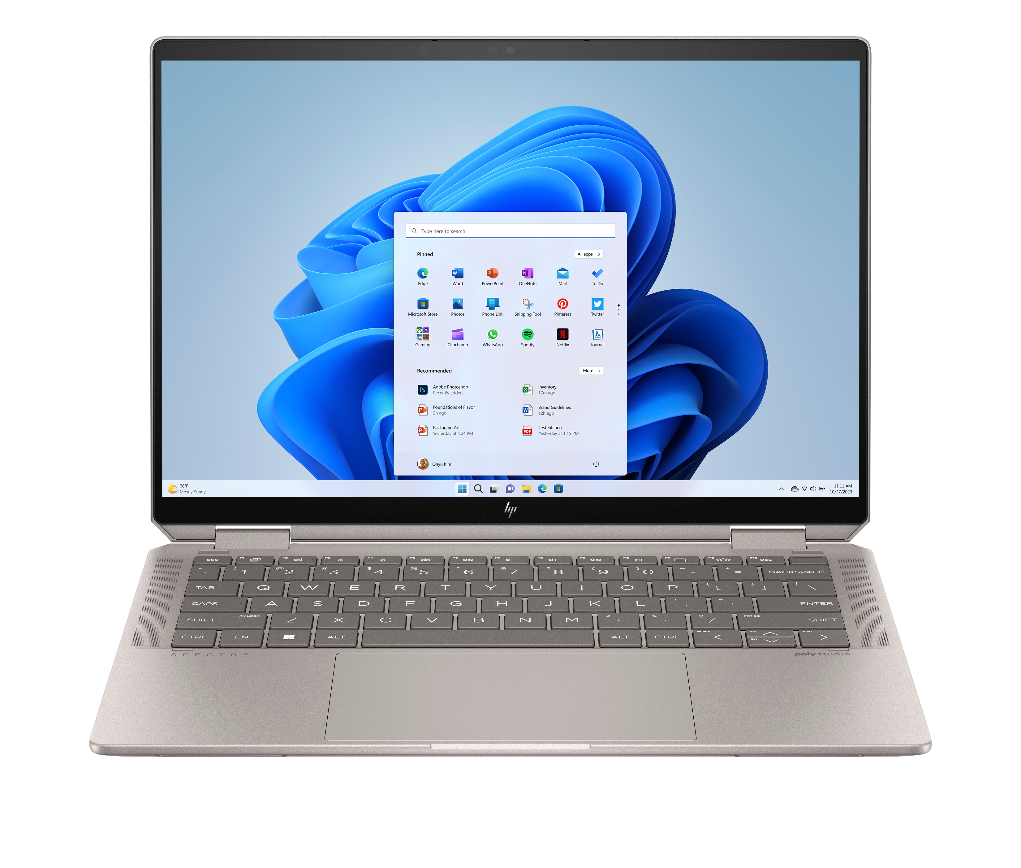 Otwarty laptop z menu startowym Windows 11 i niebieskim tłem.