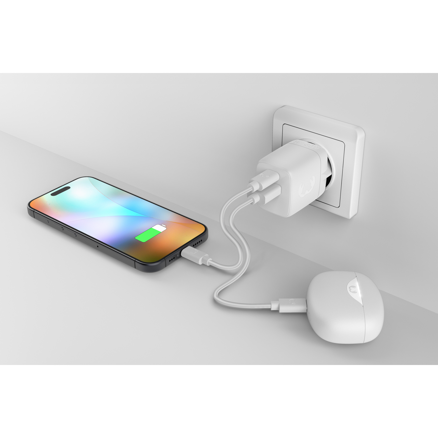 A white USB-C adapter charges a smartphone and a wireless charging case.