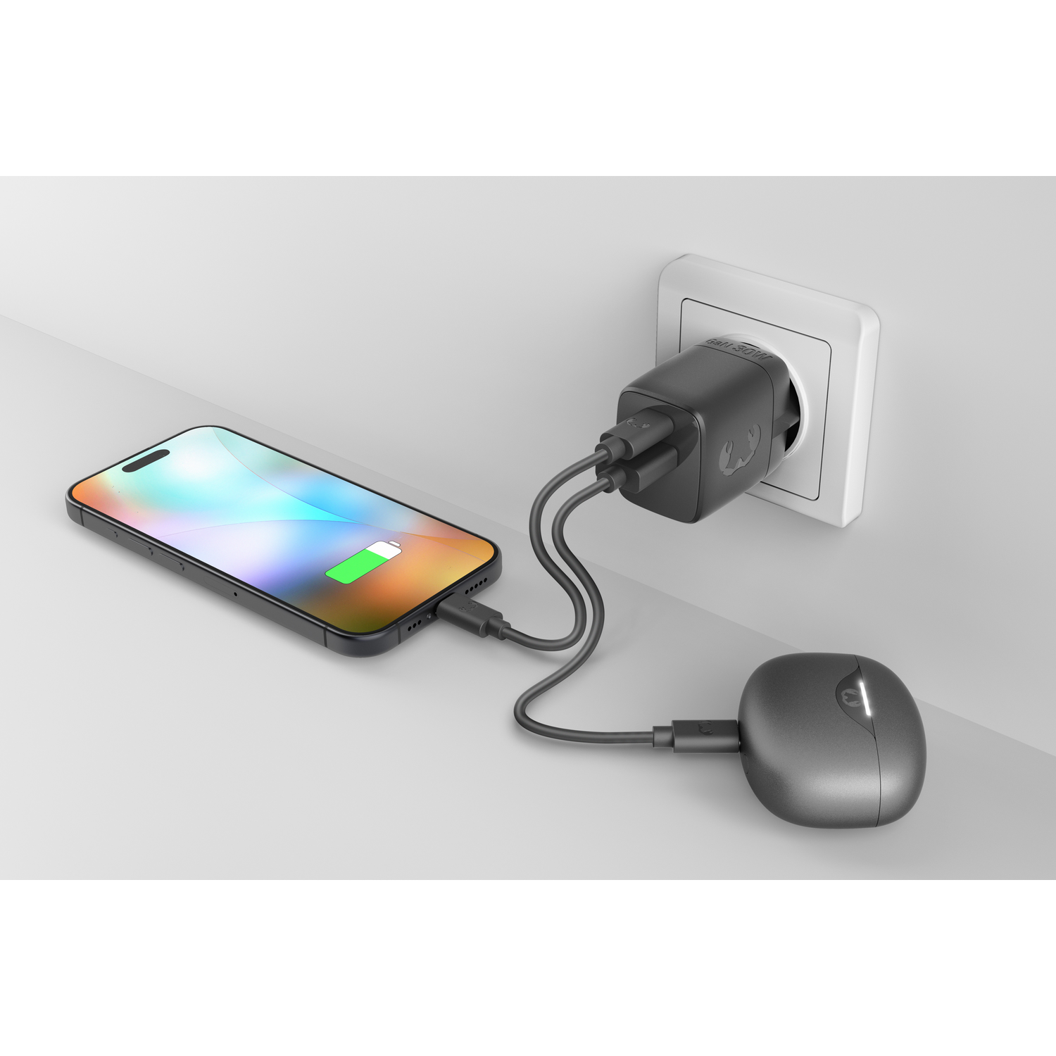 A smartphone, a mouse, and a power adapter plugged into a wall outlet.