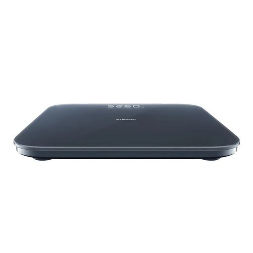 Una báscula digital oscura con pantalla blanca que muestra 52.60.