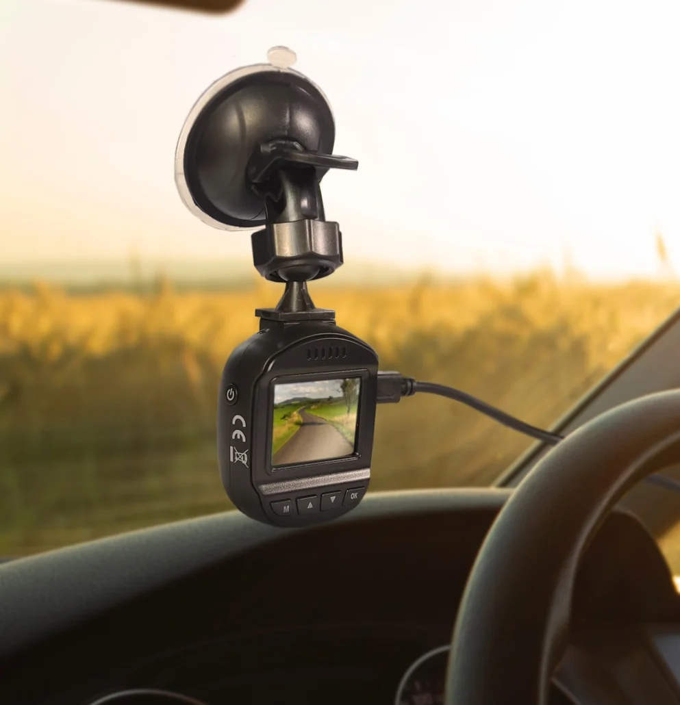 Deska rozdzielcza z kamerą samochodową pokazującą widok drogi, w słońcu.