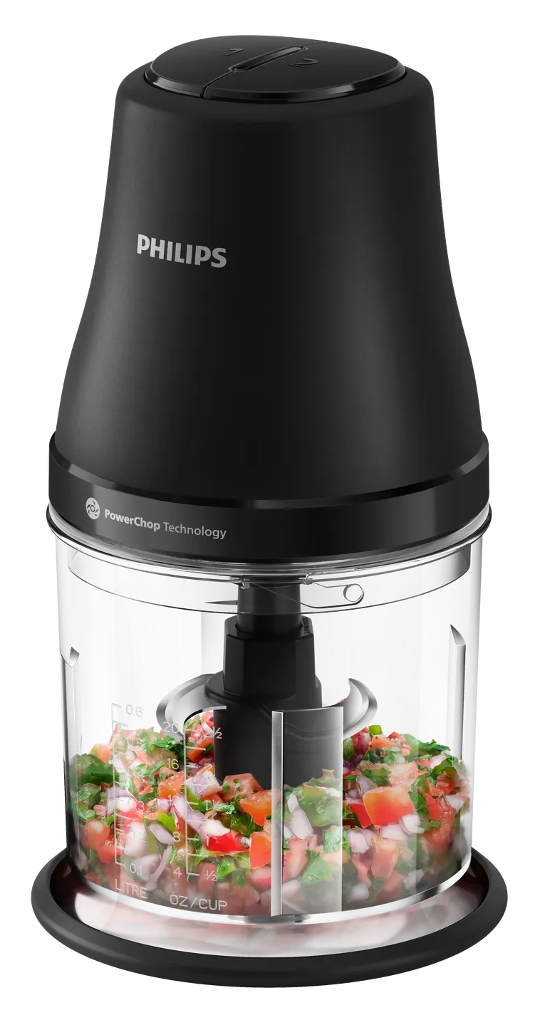Egy fekete Philips élelmiszer aprító, átlátszó tartályban aprított zöldségekkel.