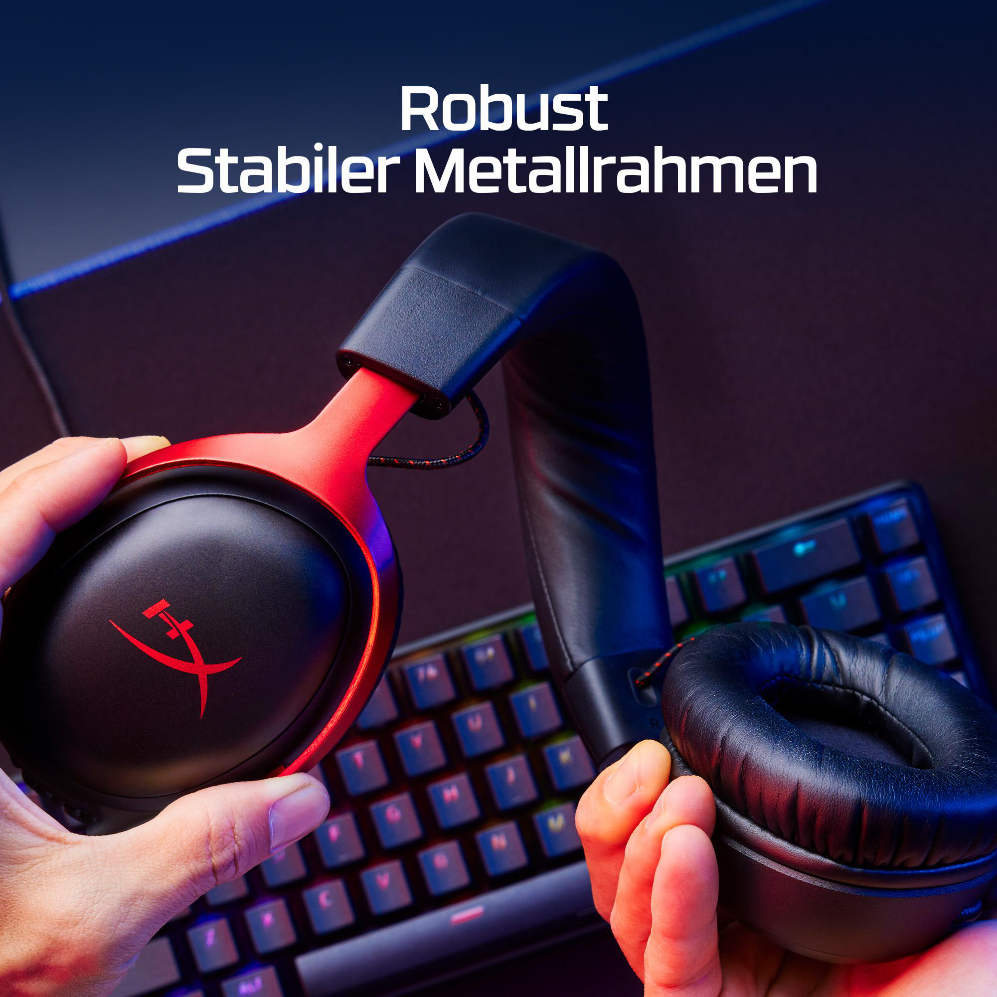 Person hält schwarze Kopfhörer mit roten Akzenten über einer Tastatur.