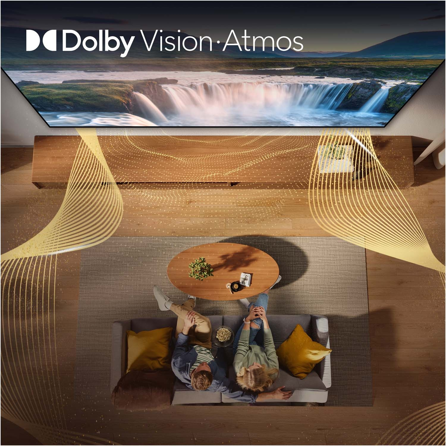 Una coppia seduta su un divano guarda una TV che mostra Dolby Vision Atmos.