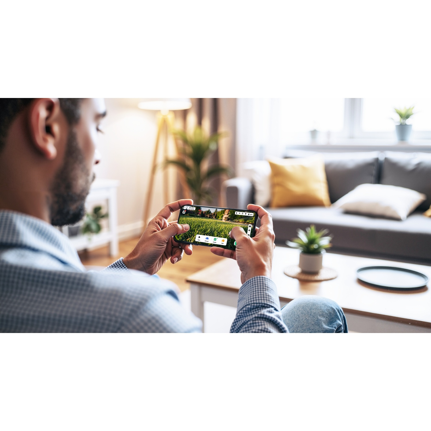 Uomo tiene telefono mostrando video di prato verde con picnic.