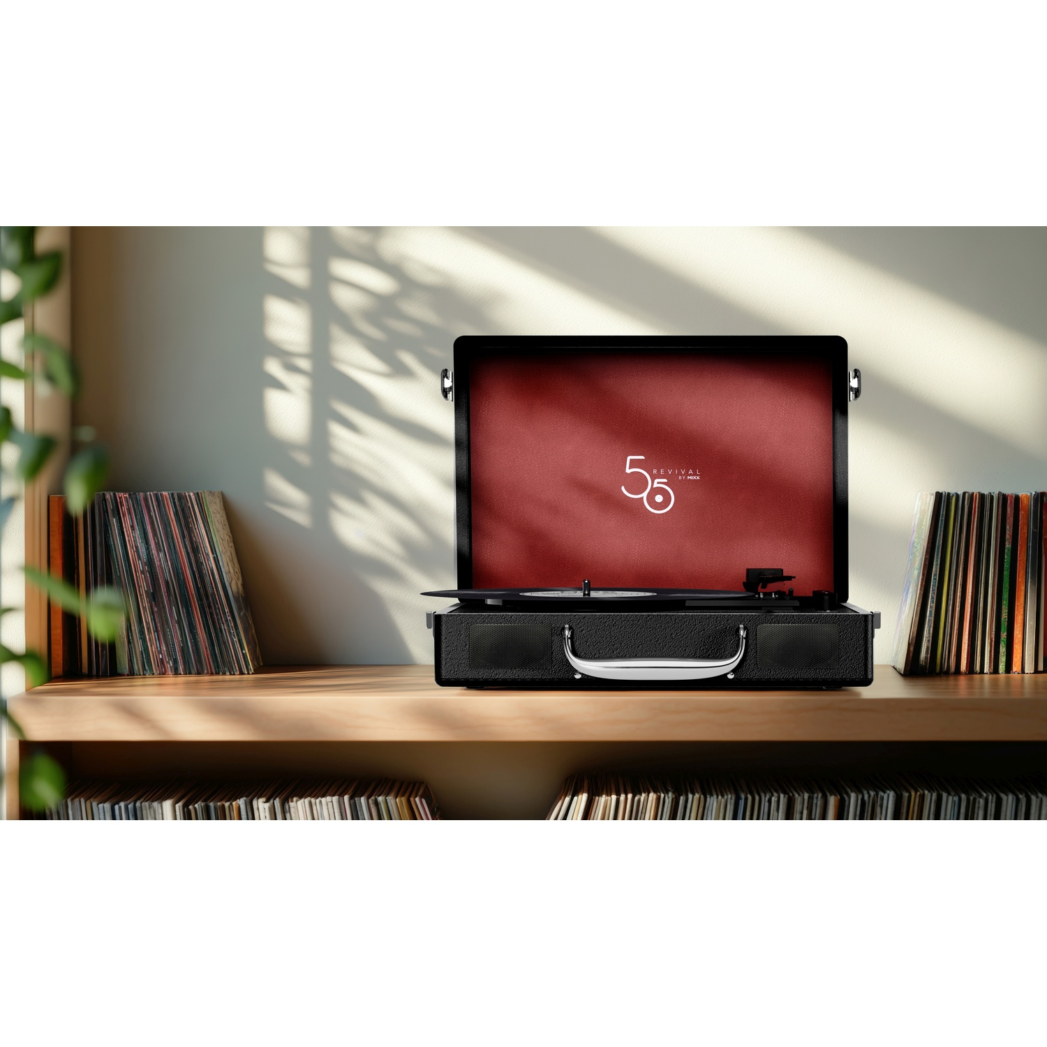 Zwarte platenspeler met rode binnenkant op plank met vinylplaten. Zonlicht valt binnen.