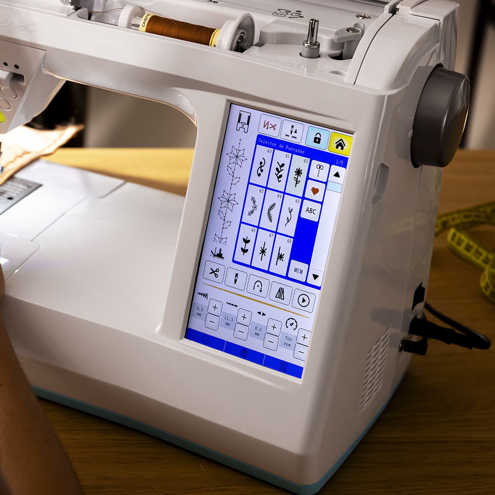 Máquina de coser moderna con pantalla táctil que muestra patrones y ajustes.