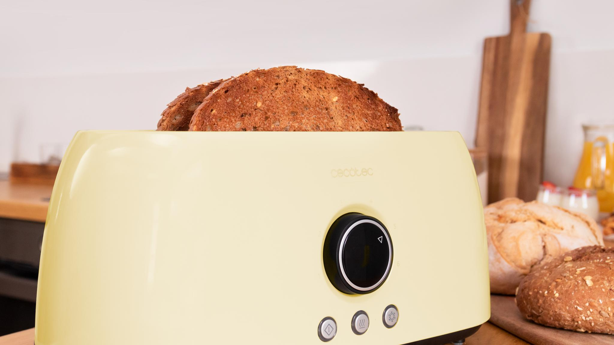 Una tostadora amarillo claro con dos rebanadas de pan.