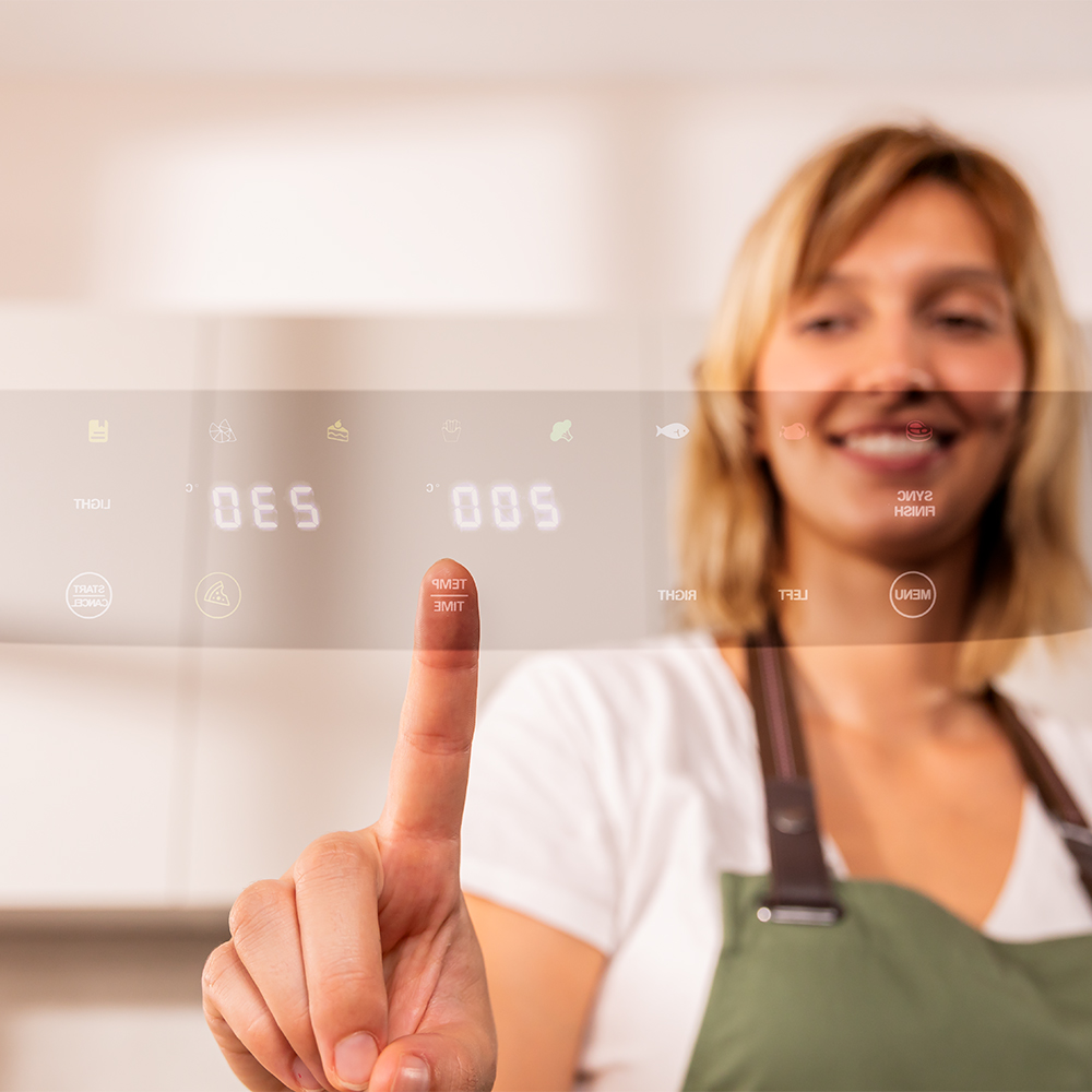 Mujer toca una pantalla digital con iconos de cocina y números.