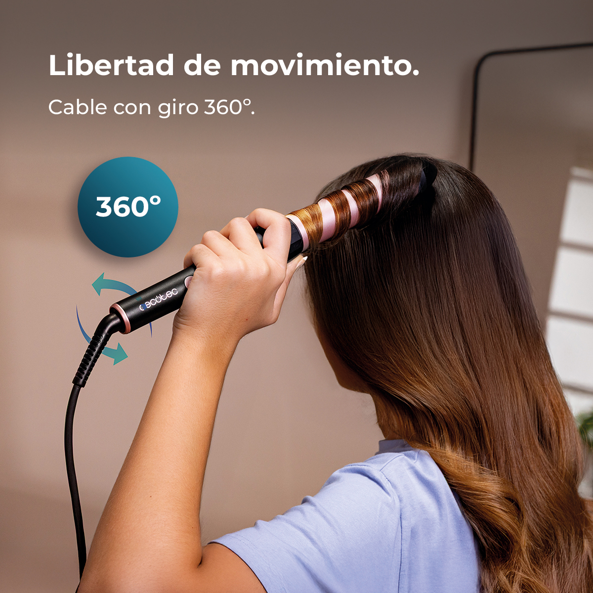 Una mano usa un rizador con cable de 360° para peinar cabello castaño.