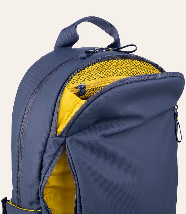 Una mochila azul oscuro con compartimentos abiertos que revelan un interior amarillo brillante.