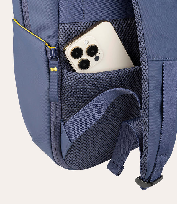Un smartphone descansa en el bolsillo de malla de una mochila azul.
