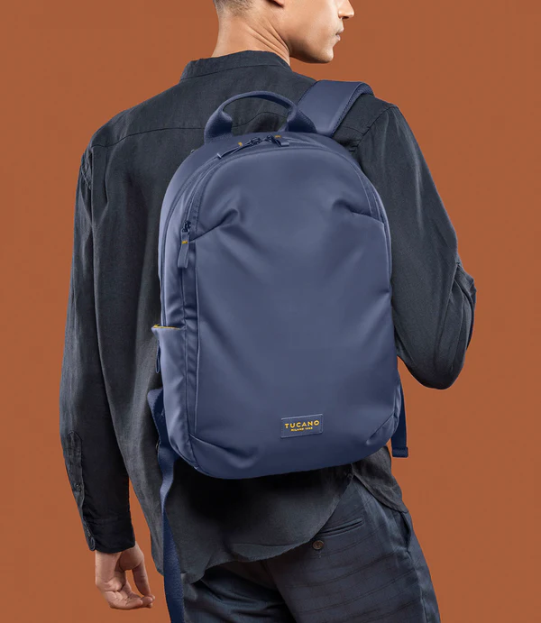 Hombre con mochila azul oscuro, fondo marrón.